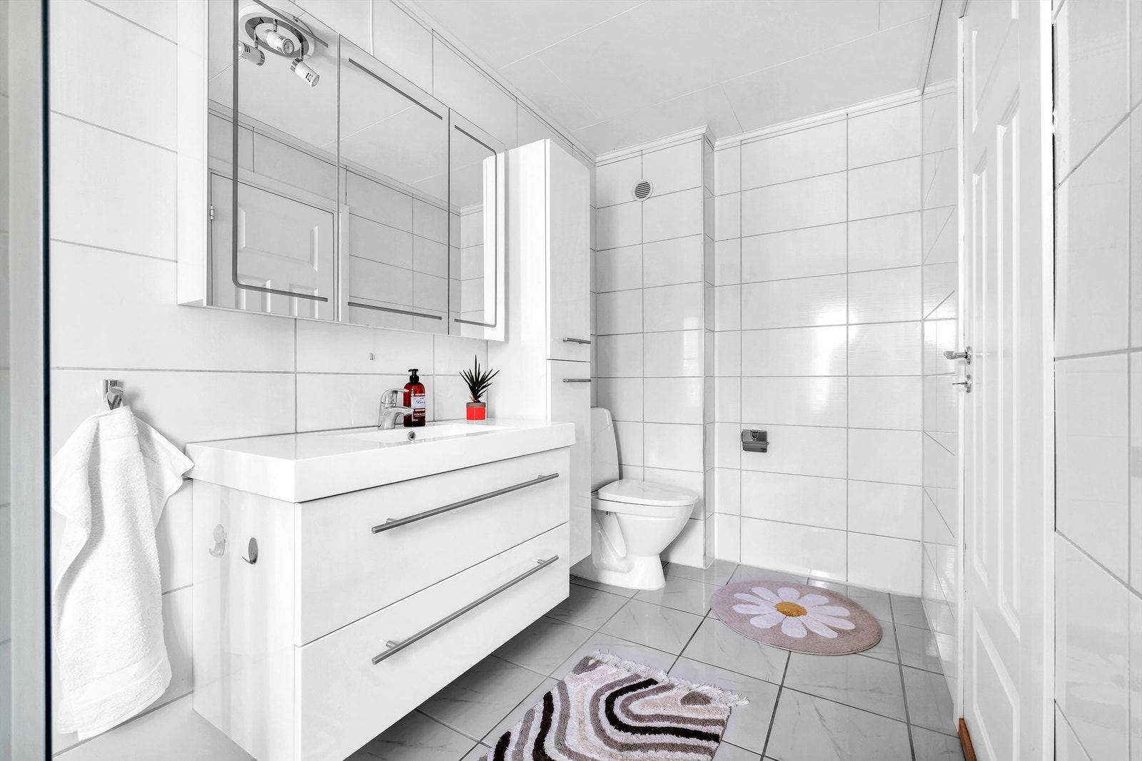 Videre er det en heldekkende servant, speilskap med integrert belysning, vegghengt høyskap, dusjkabinett og gulvstående toalett. Galleribilde