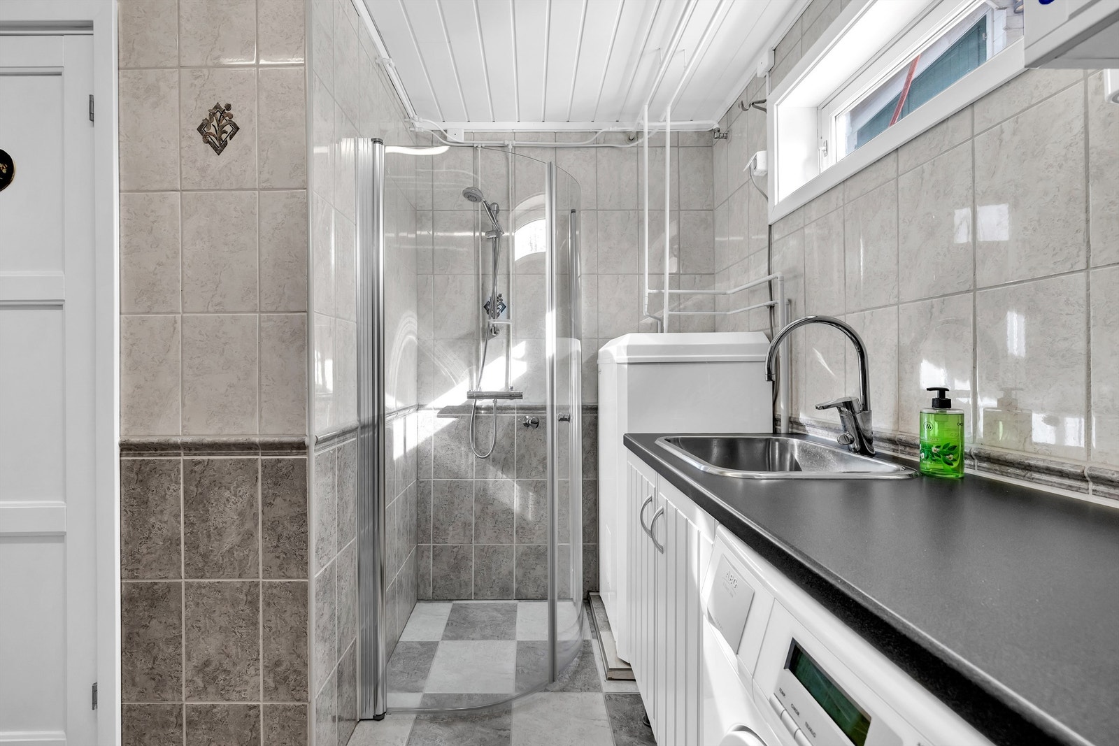 Vaskerommet som ligger i underetasjen, har flislagte overflater, varme i gulv og gulvstående innredning med benkeplate av laminat og nedfelt utslagsvask. Galleribilde