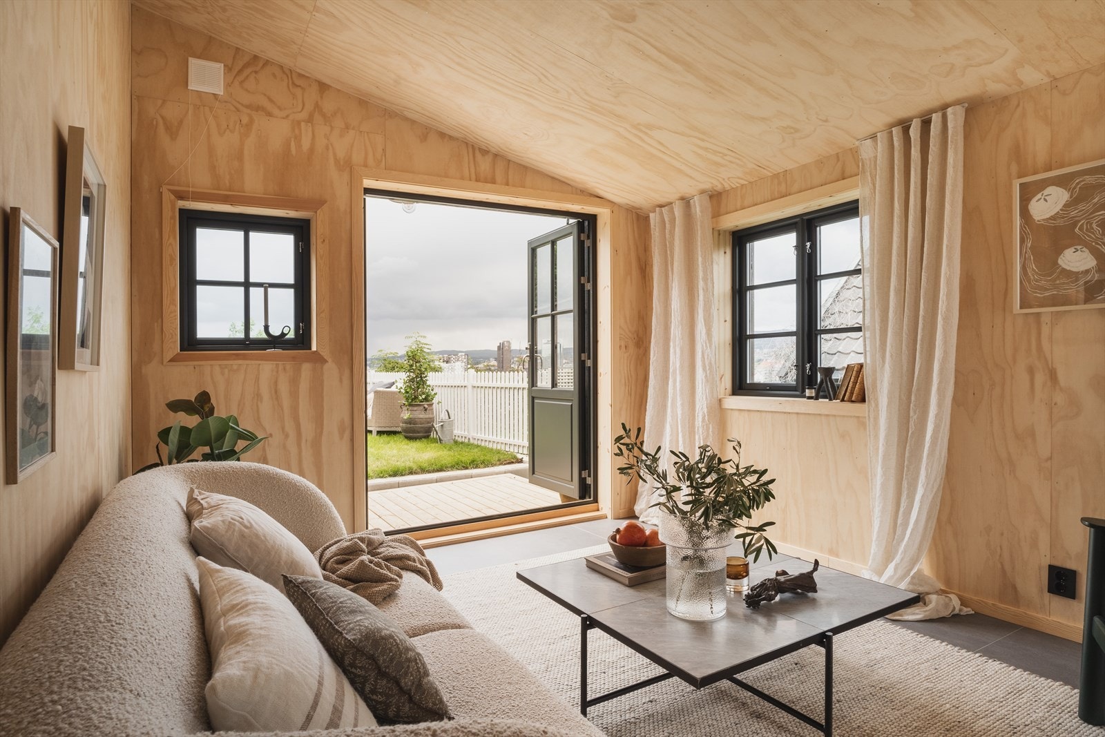 Stuen i uthuset er innredet med fliser på gulv og finerplater i naturlig eik Galleribilde