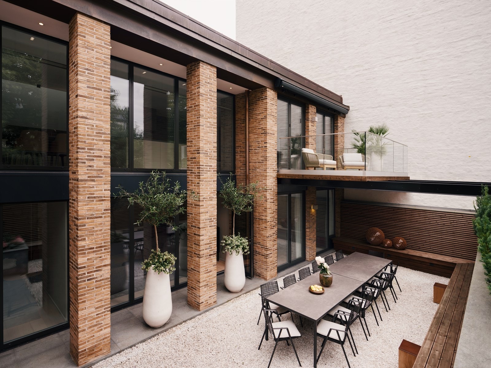 Lekker fasade i teglstein med store vindusflater og uteplasser på begge plan. Galleribilde