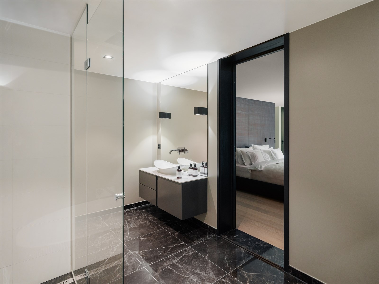 Delikat bad med stor dusjnisje, vegghengt toalett, badekar og servant med innredning. Galleribilde