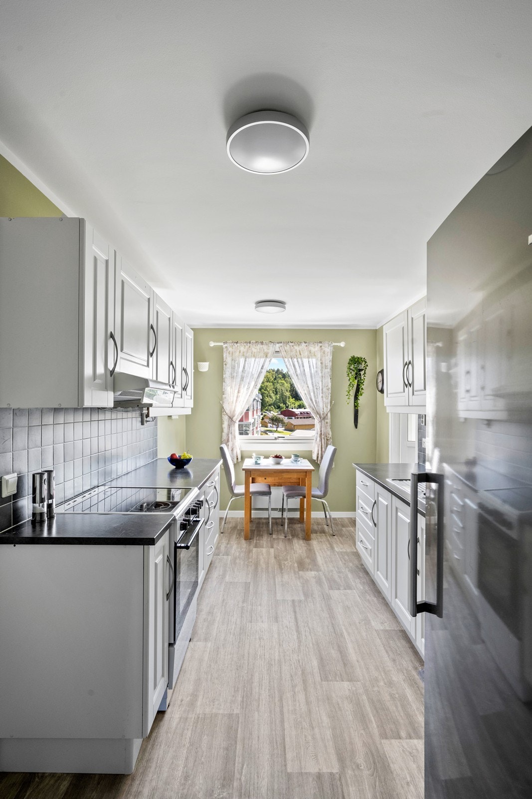 Kjøkkenet har hvit innredning med profilerte fronter fra 2013 og laminert benkeplate. Galleribilde