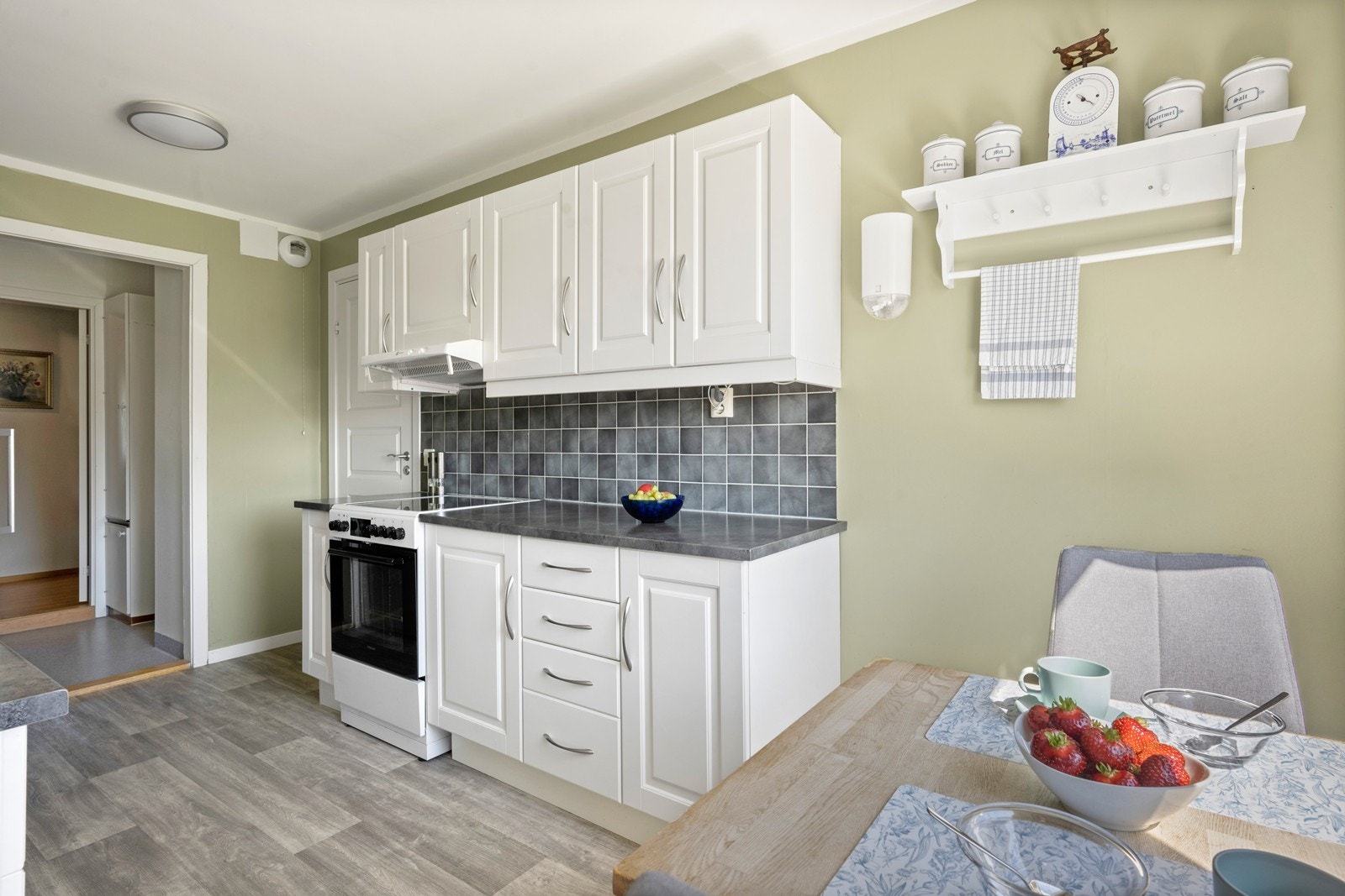 Mellom benkeplate og overskap er det flislagt, noe som gir et pent og praktisk arbeidsområde. Galleribilde