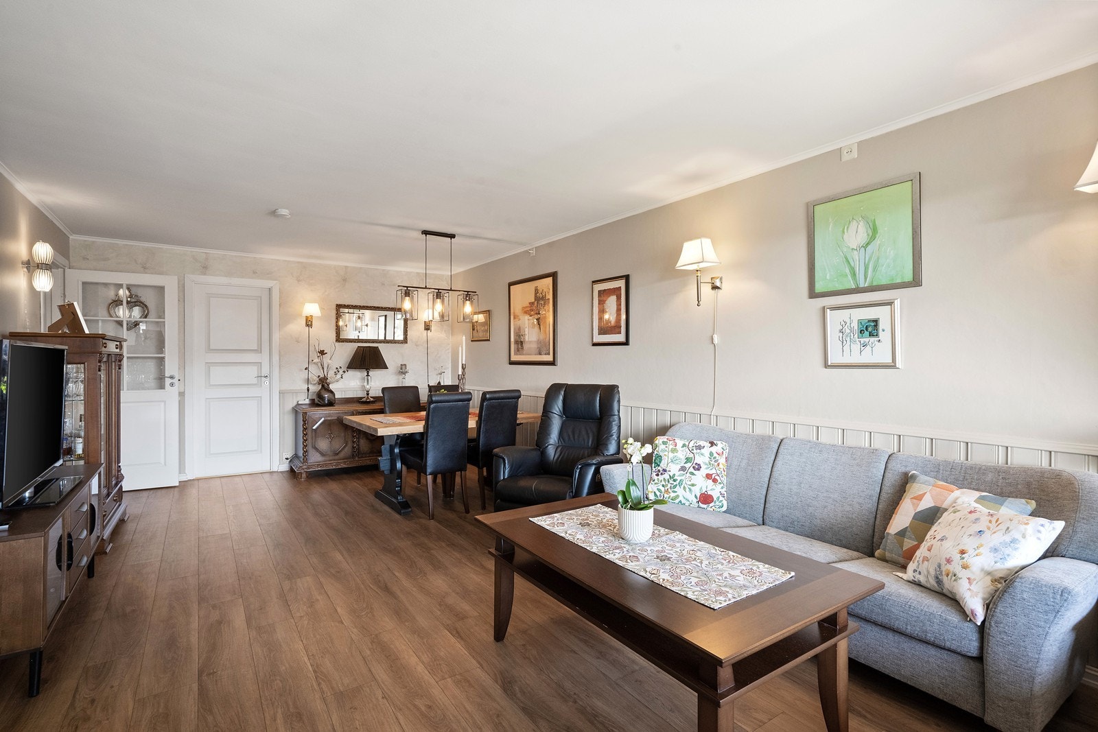 Her er det god plass til både sofagruppe og spisebord, noe som gjør rommet ideelt for både hverdagsliv og sosiale sammenkomster. Galleribilde