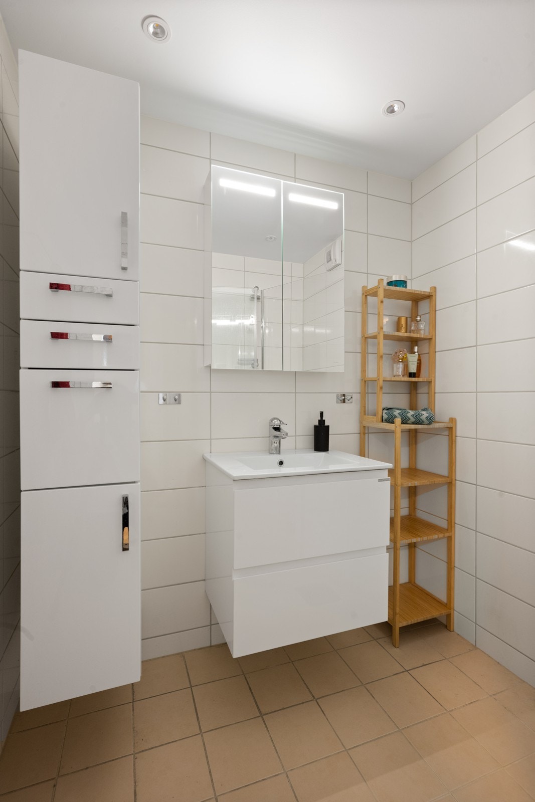 Badet ble oppgradert i 2019 i regi av borettslaget, inkludert utskifting av rørstammer. Rommet fremstår moderne med flislagte overflater - beige fliser på gulv og hvite på vegger - samt slett tak med innfelte spotter som gir god belysning. Galleribilde