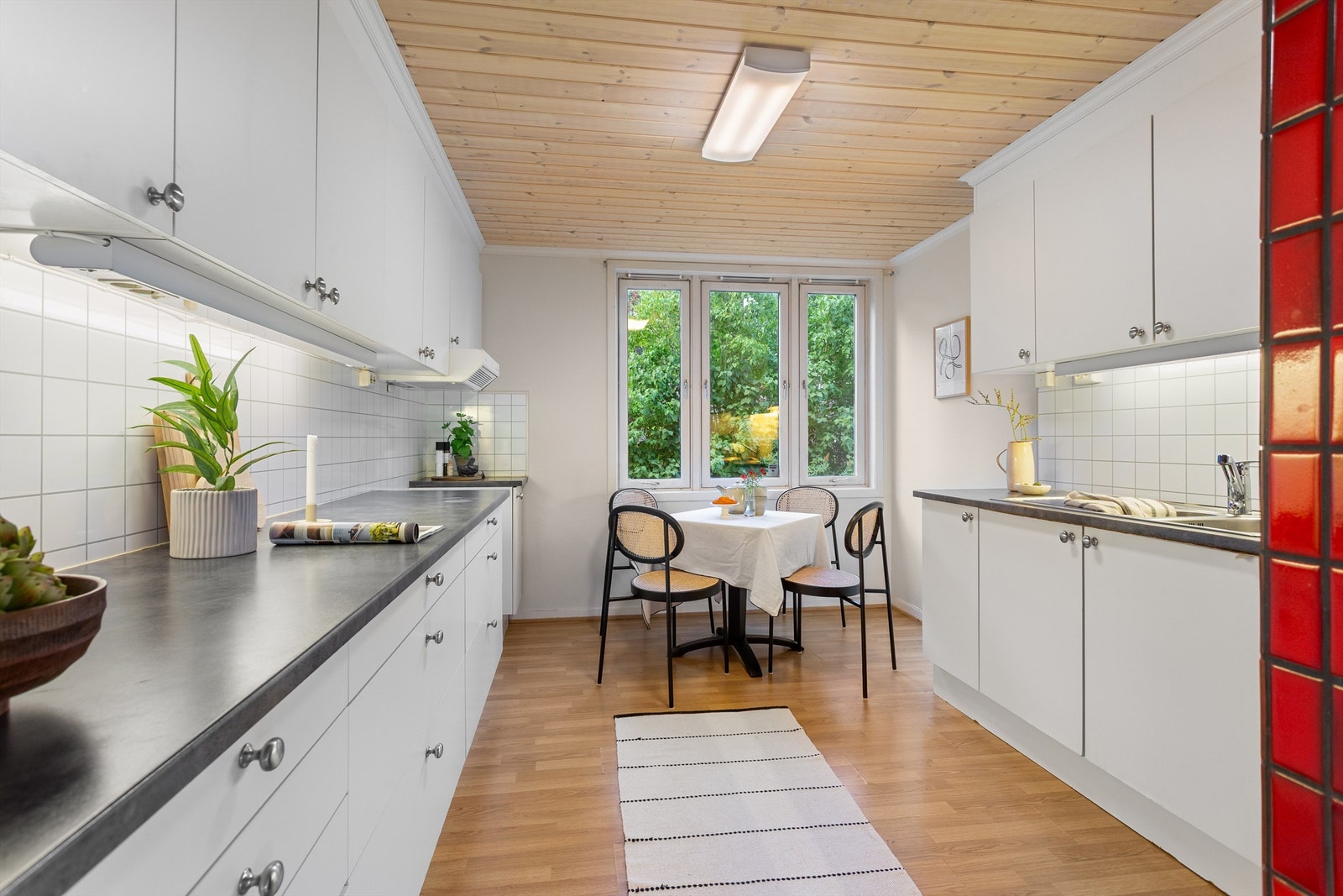 Kjøkkeninnredning med over- og underskap i hvit samt glatt utførelse Galleribilde