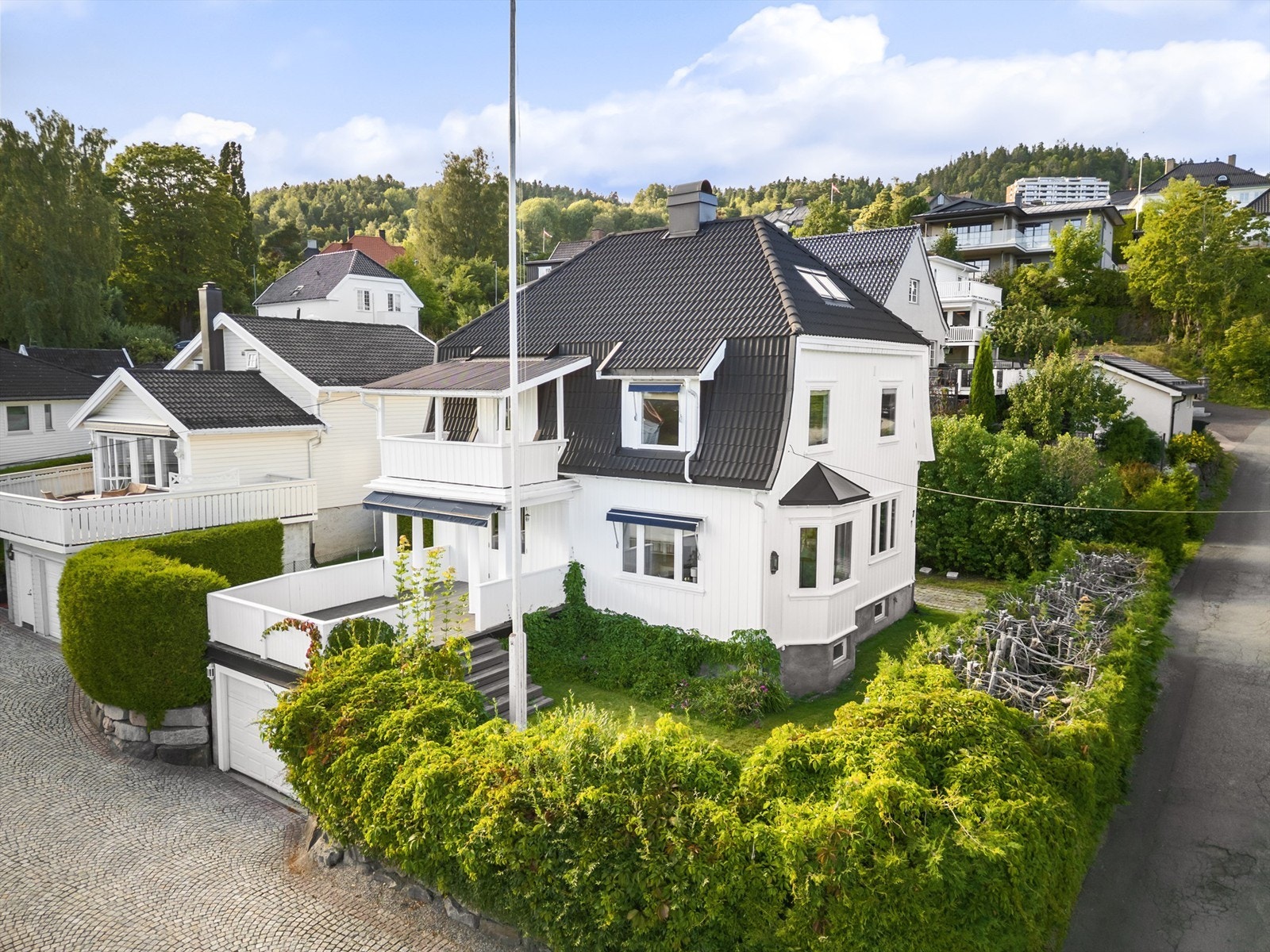 Tomten er pent opparbeidet med gressplen, hekk, prydbusker og diverse beplantninger Galleribilde