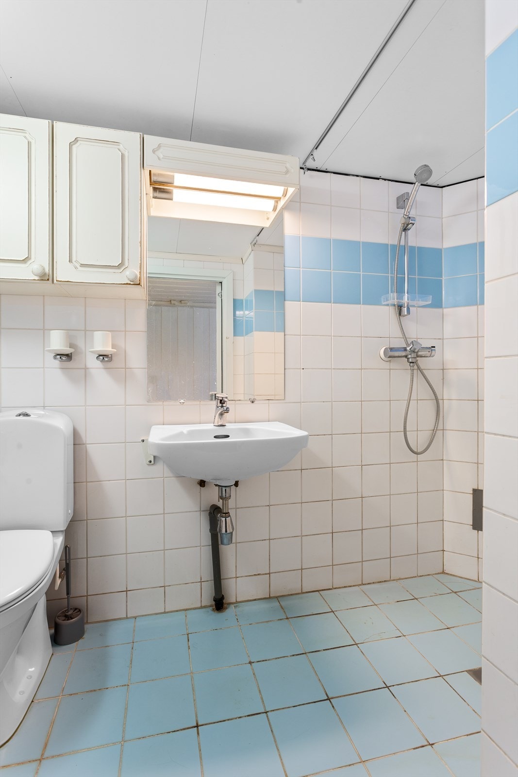 Flislagt bad i kjeller med dusj i hjørne og varmekabler i gulv Galleribilde