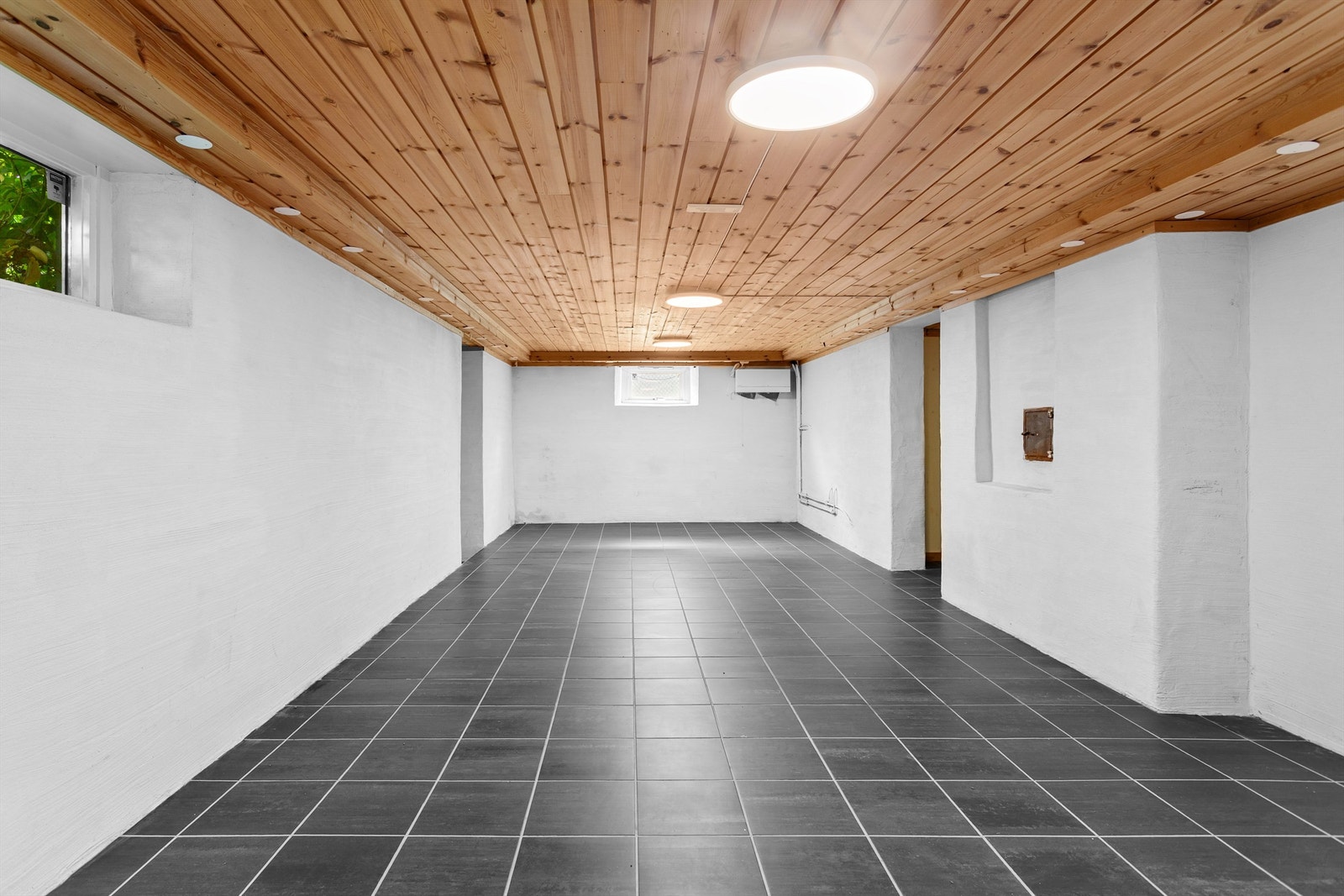 Kjellerrom/gang med fliser på gulv, malte vegger og panel i himling - Rommet er ikke godkjent for varig opphold Galleribilde