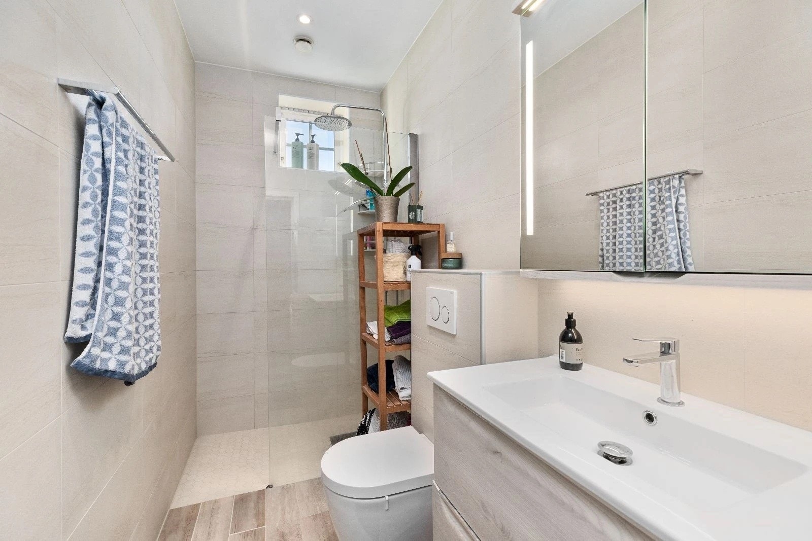 Flislagt bad med wc, servant, dusjhjørne og vaskemaskin/tørketrommel. Varmekabler. Galleribilde