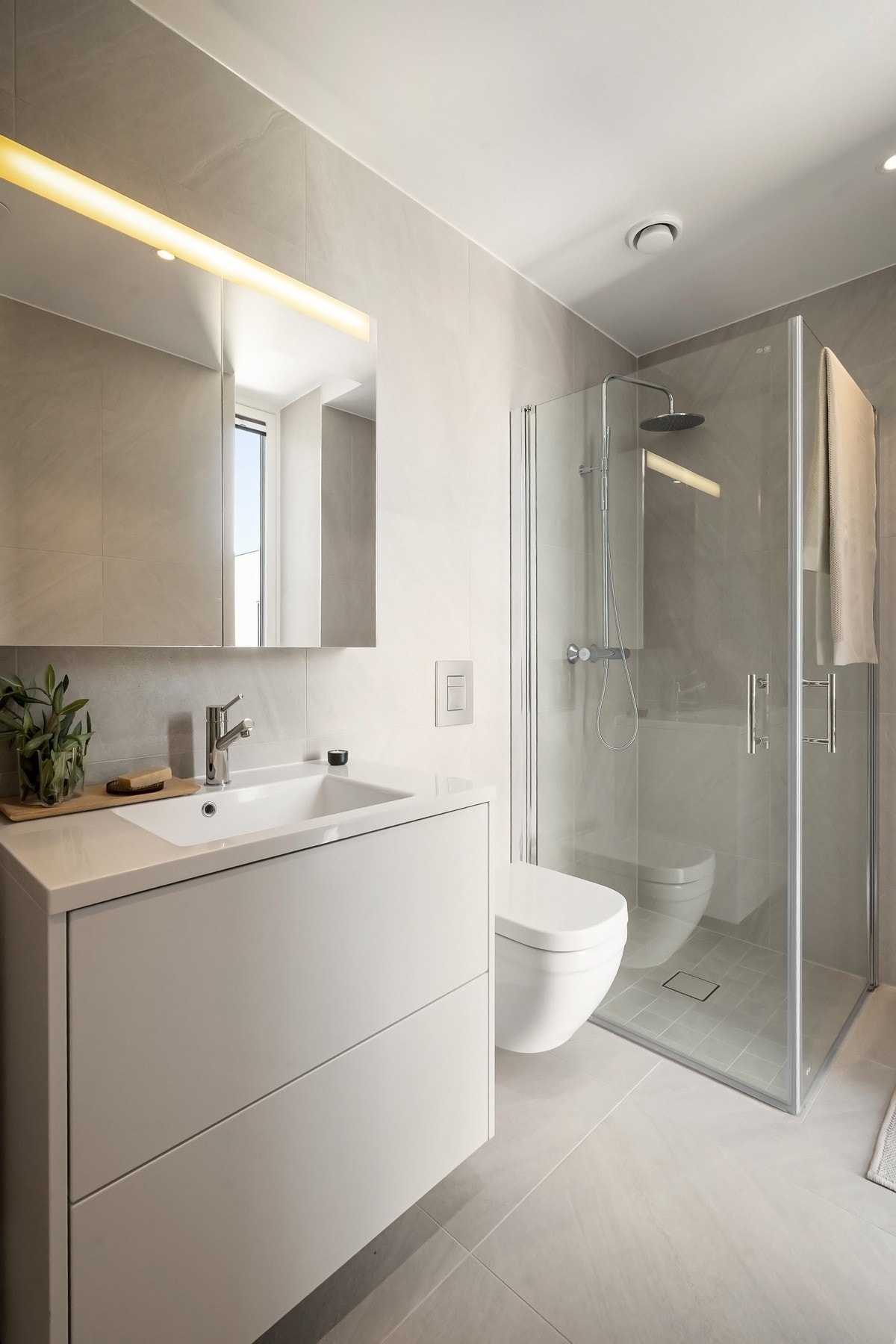 Lekkert baderom med store fliser og delikate farger. Galleribilde