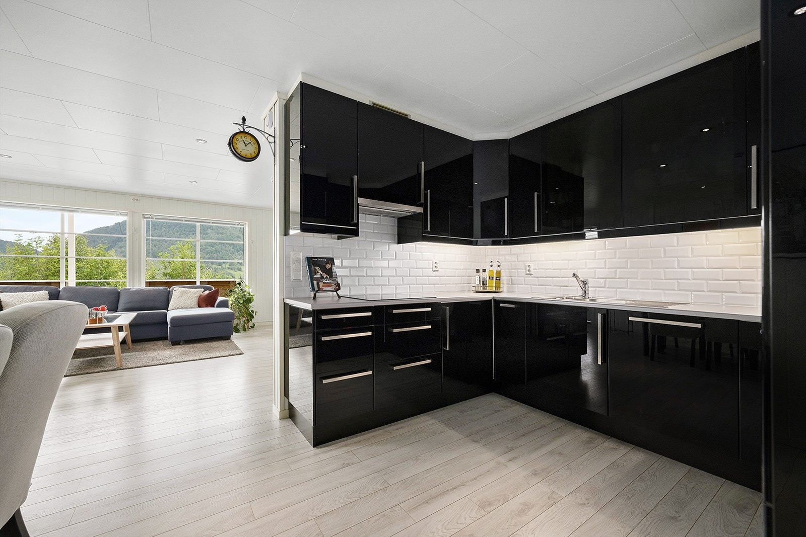 Kjøkkenet har rikelig med skap- og benkeplass. Innredningen har takhøye overskap og fronter i sort høyglans. Galleribilde