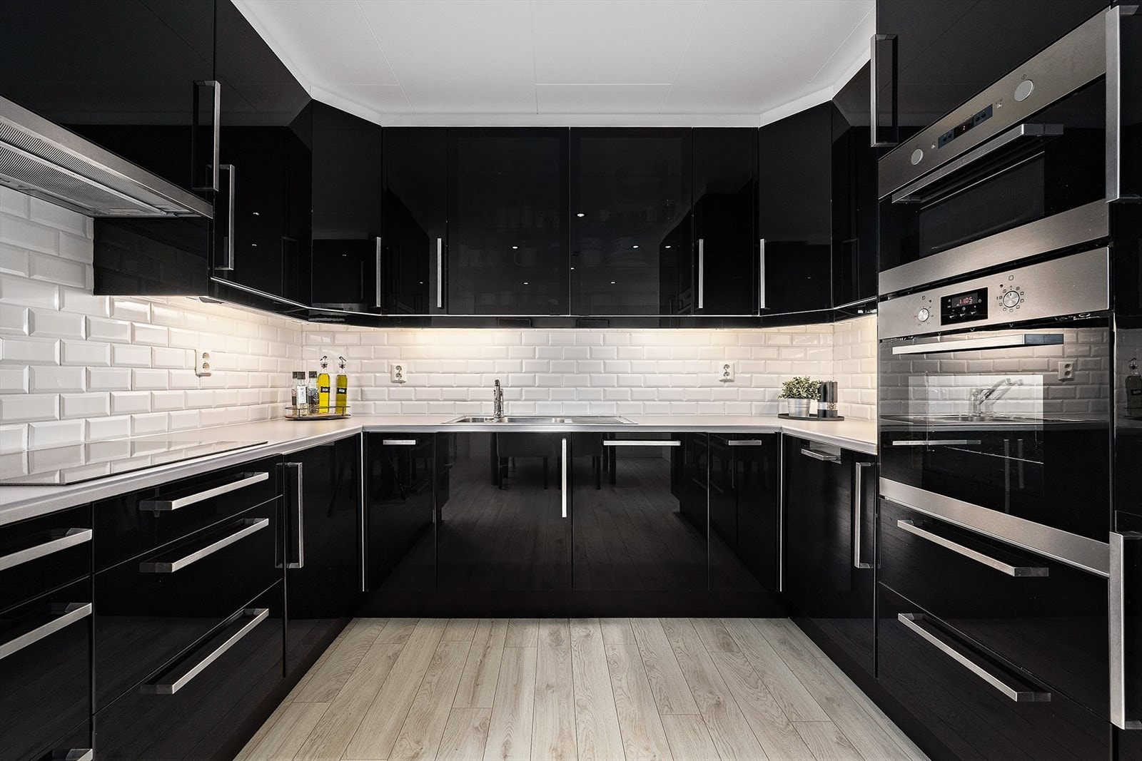 Kjøkkenet har rikelig med skap- og benkeplass. Innredningen har takhøye overskap og fronter i sort høyglans. Galleribilde