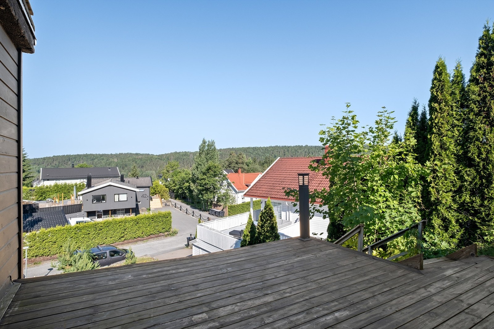 Hybelen har egen inngang, egen terrasse og flere biloppstillingsplasser på den nedre delen av tomten Galleribilde