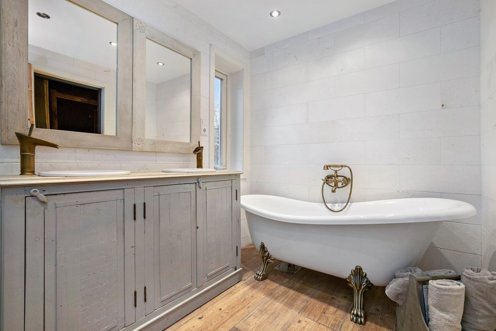 Frittstående badekar med hånddusj, vannrør av rør-i-rør og avtrekksvifte i himling Galleribilde