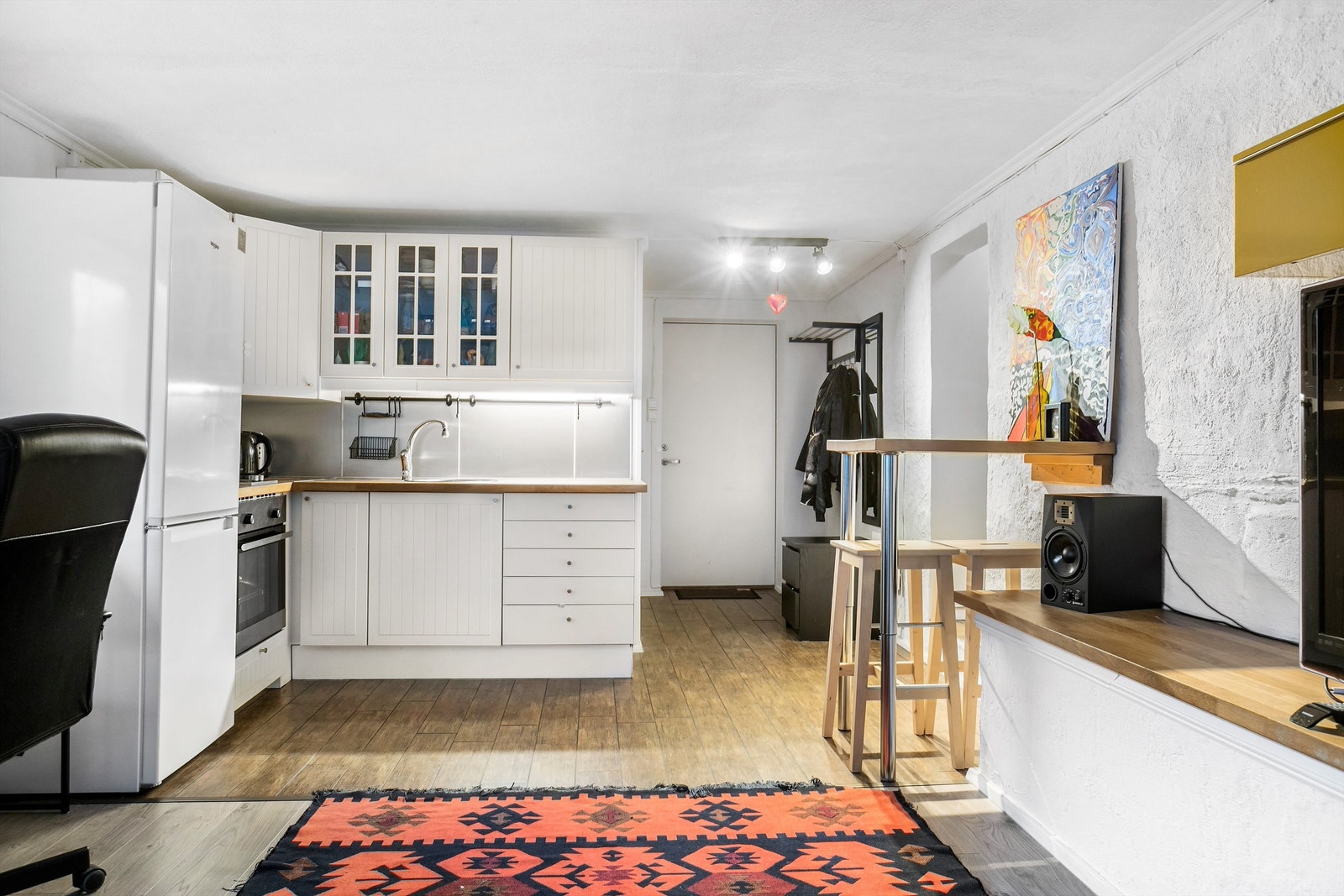 Åpen kjøkkenløsning mot stue. Frittstående kjøleskap med fryser, integrert stekeovn og platetopp. Ventilator i overskap Galleribilde