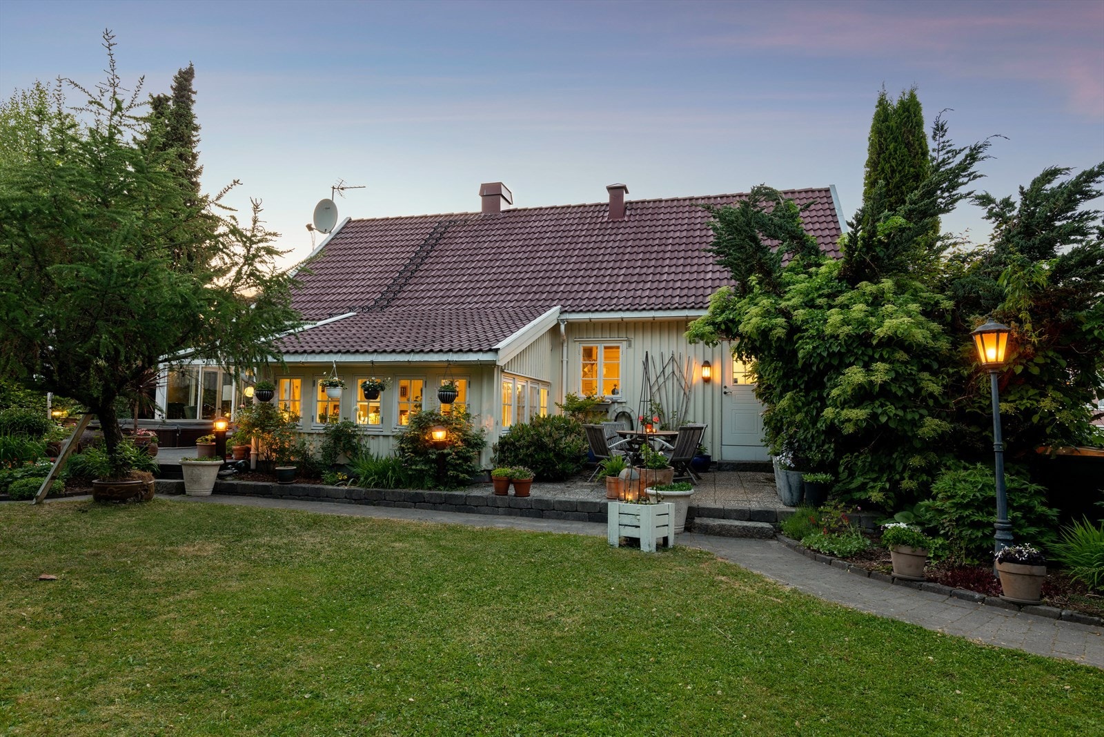 Fra begge vinterhagene har man direkte utgang til boligens svært pent opparbeidede tomt og uteområde Galleribilde