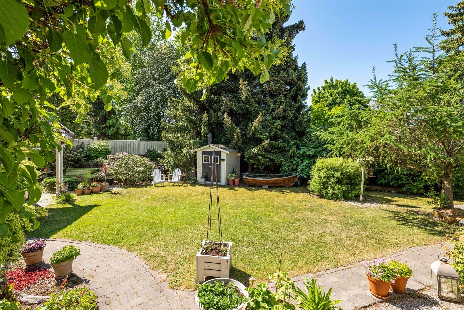 Solrik og flat tomt. Legg merke til at tomten ikke går langs støyskjermen/gjerdet, men litt inn i hagen. Kartskissen ligger vedlagt i salgsoppgaven med tomtegrensene. Galleribilde