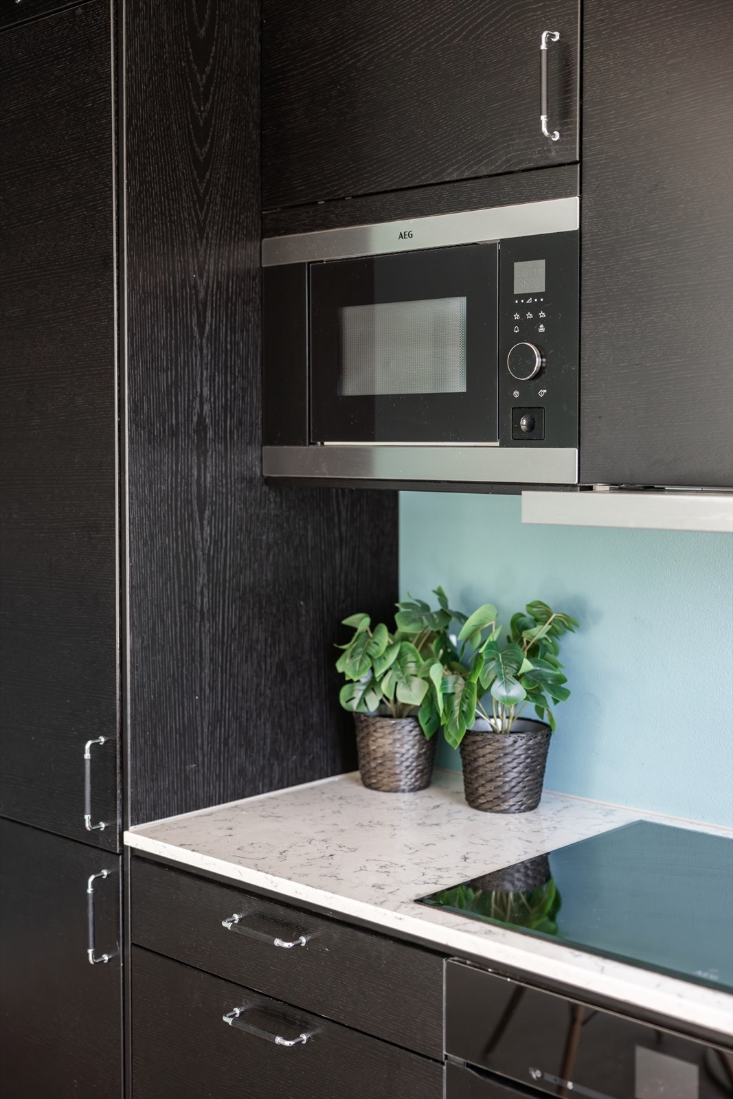 Den lyse benkeplaten i marmor er en flott kontrast til det ellers mørke kjøkkenet. Galleribilde