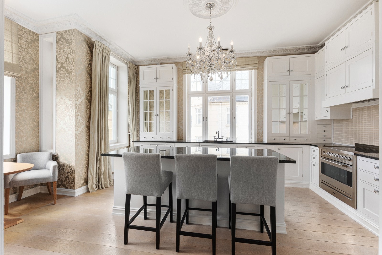 Lyst og innbydende kjøkken i klassisk stil, preget av god plass og flotte vindusflater Galleribilde