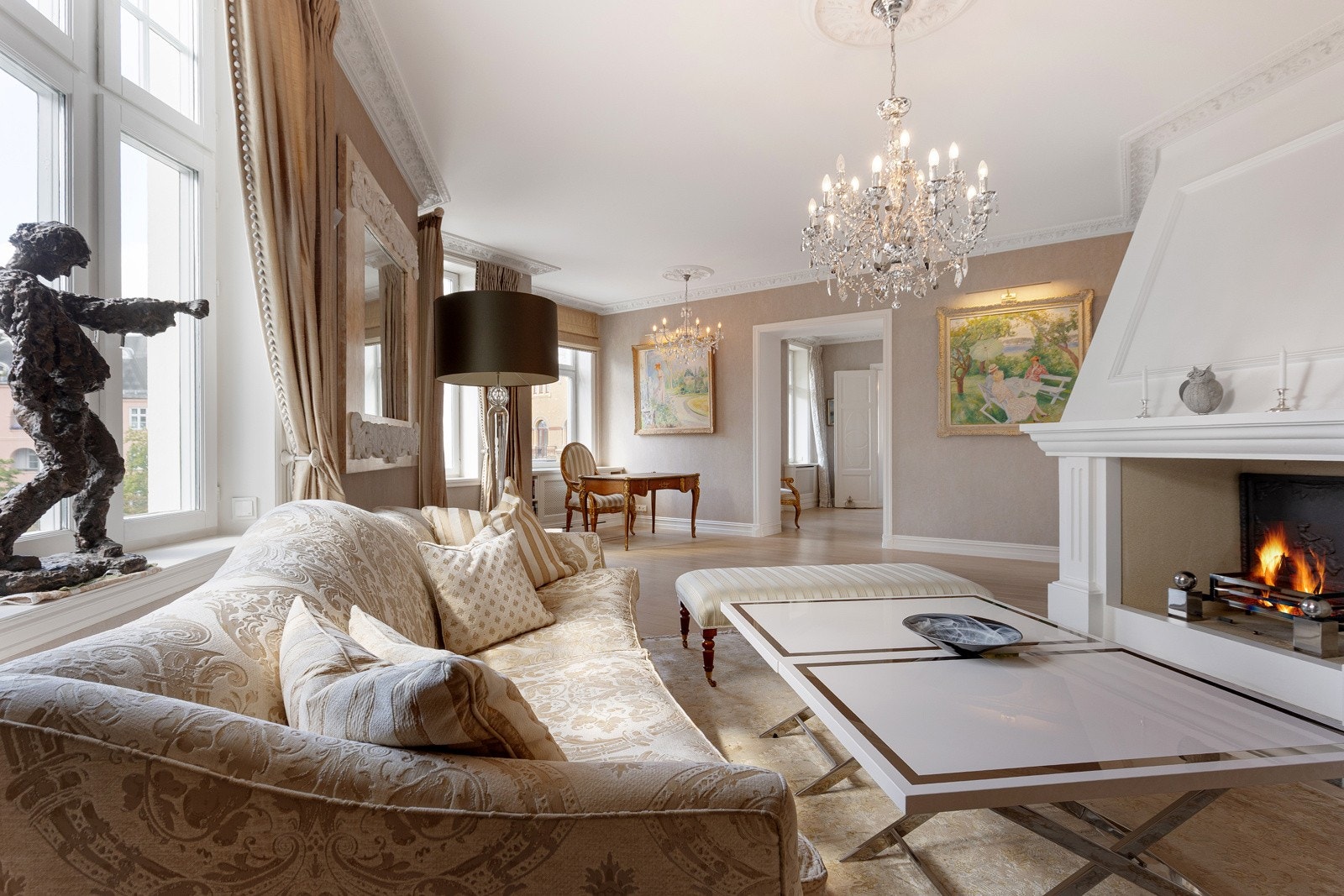 Elegant dagligstue med åpen peis og store vindusflater. Leiligheten varmes opp med fjernvarme Galleribilde