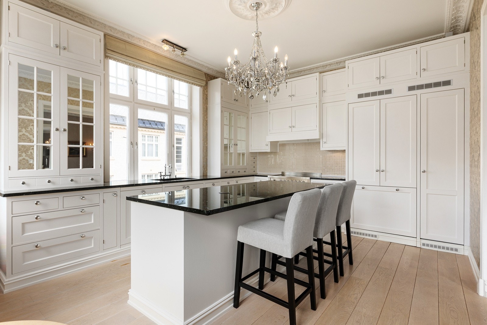 Kjøkkeninnredning med profilerte fronter og solid benkeplate i stein. Leveres med integrerte hvitevarer som komfyr, vinskap, kjøl/frys, oppvaskmaskin og mikrobølgeovn. Galleribilde