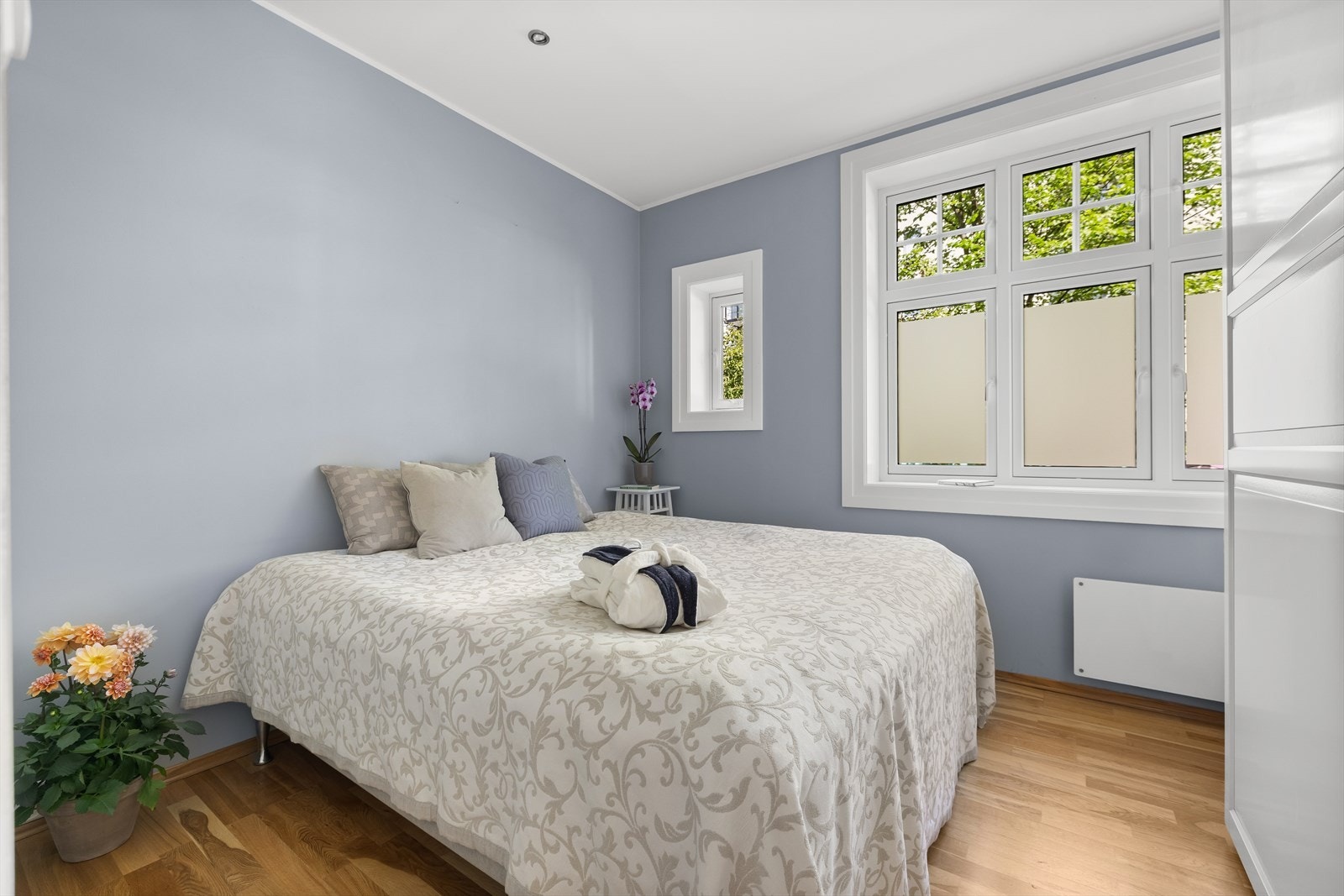 Romslig soverom som vender ut mot en stille og grønn bakgård Galleribilde