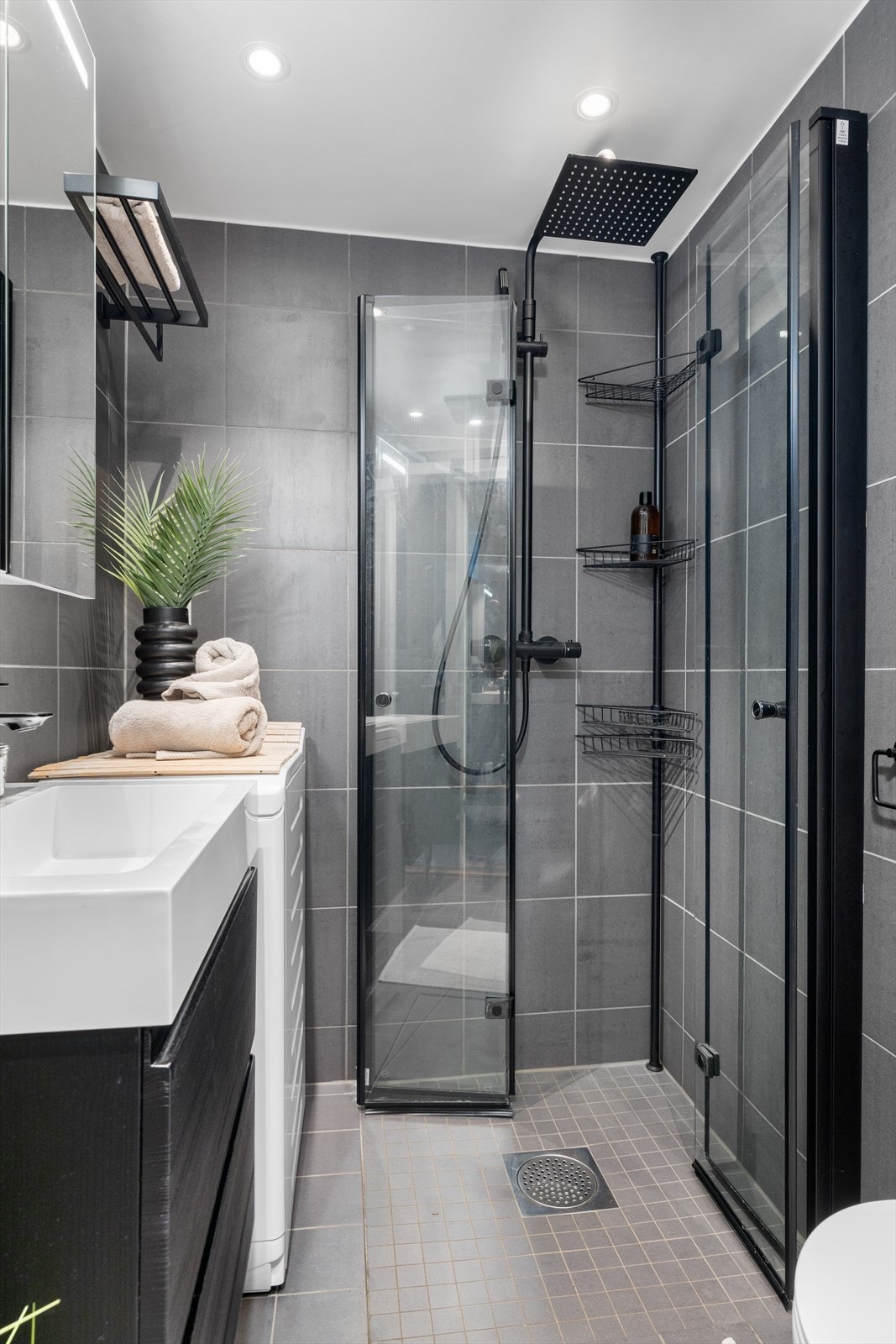 Svarte detaljer gir dusjhjørnet et moderne uttrykk, kombinert med en regnfallsdusj. Galleribilde