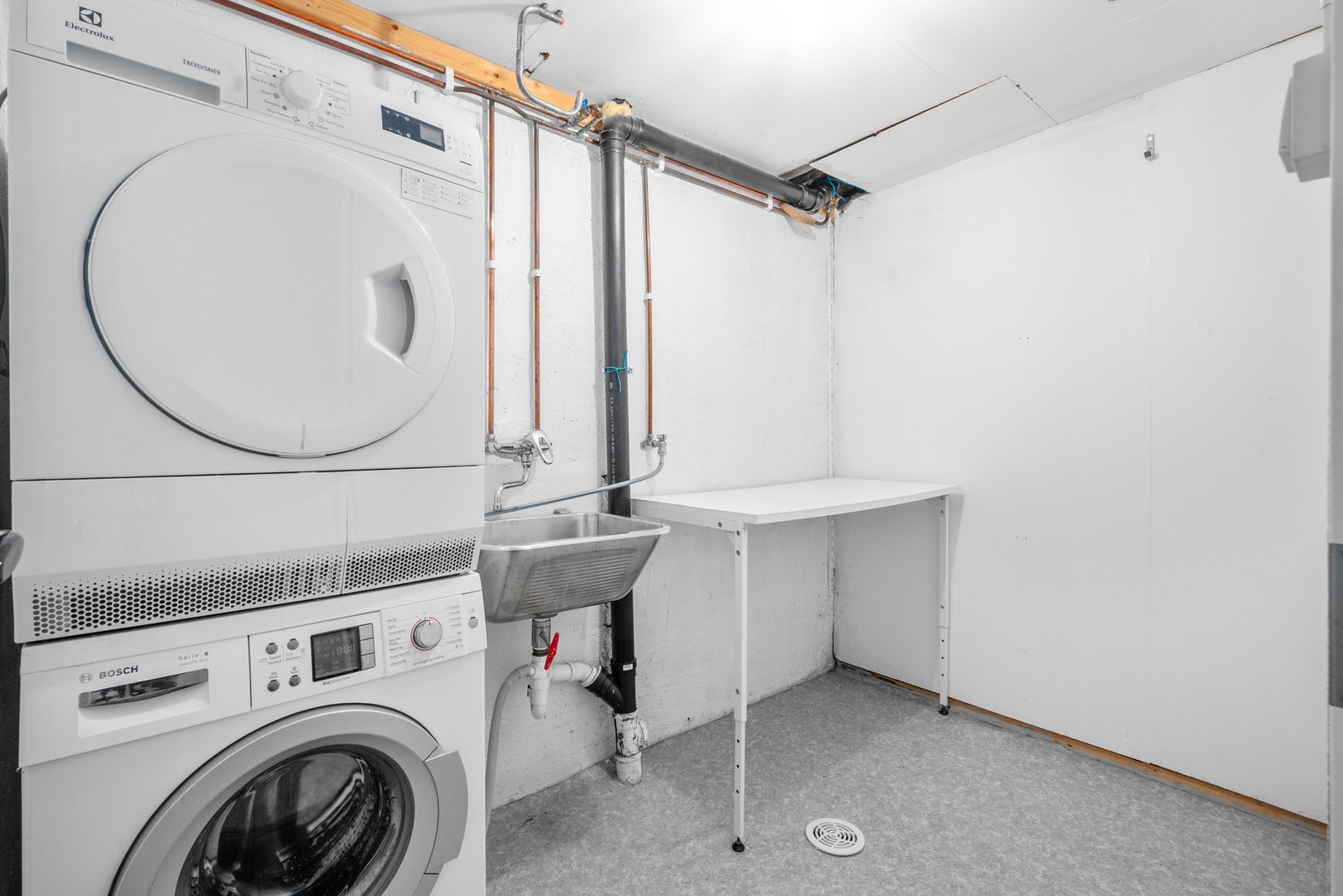 Vaskerom innredet med skyllekar med 1-greps blandebatteri og opplegg til vaskemaskin. Galleribilde