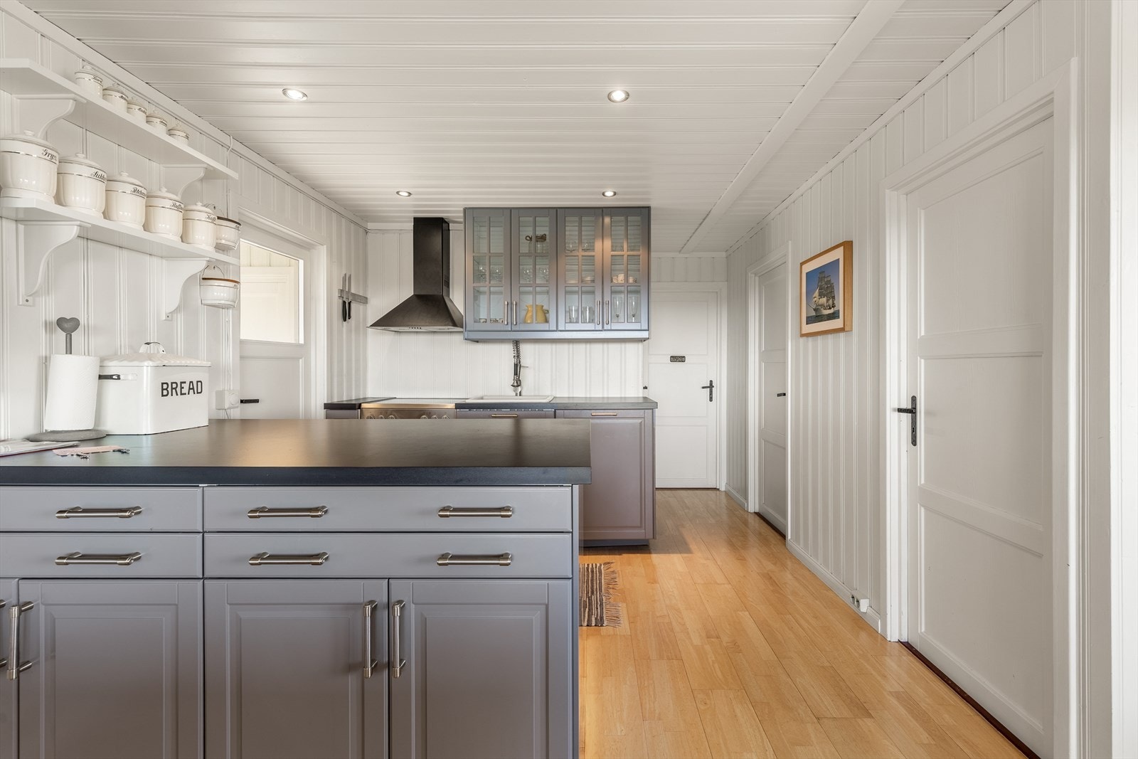 Innredning: Kjøkkeninnredning med overskap, underskap og kjøkkenøy. Fronter i slett utførelse. Over og underskap og øy. Utslagsvask. Integrert oppvaskmaskin og kjøleskap for montering i underskap Galleribilde