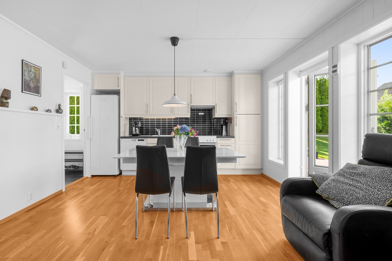 Kjøkken med takhøye skap og god plass til spisestue - Utgang til terrasse og hage. Galleribilde