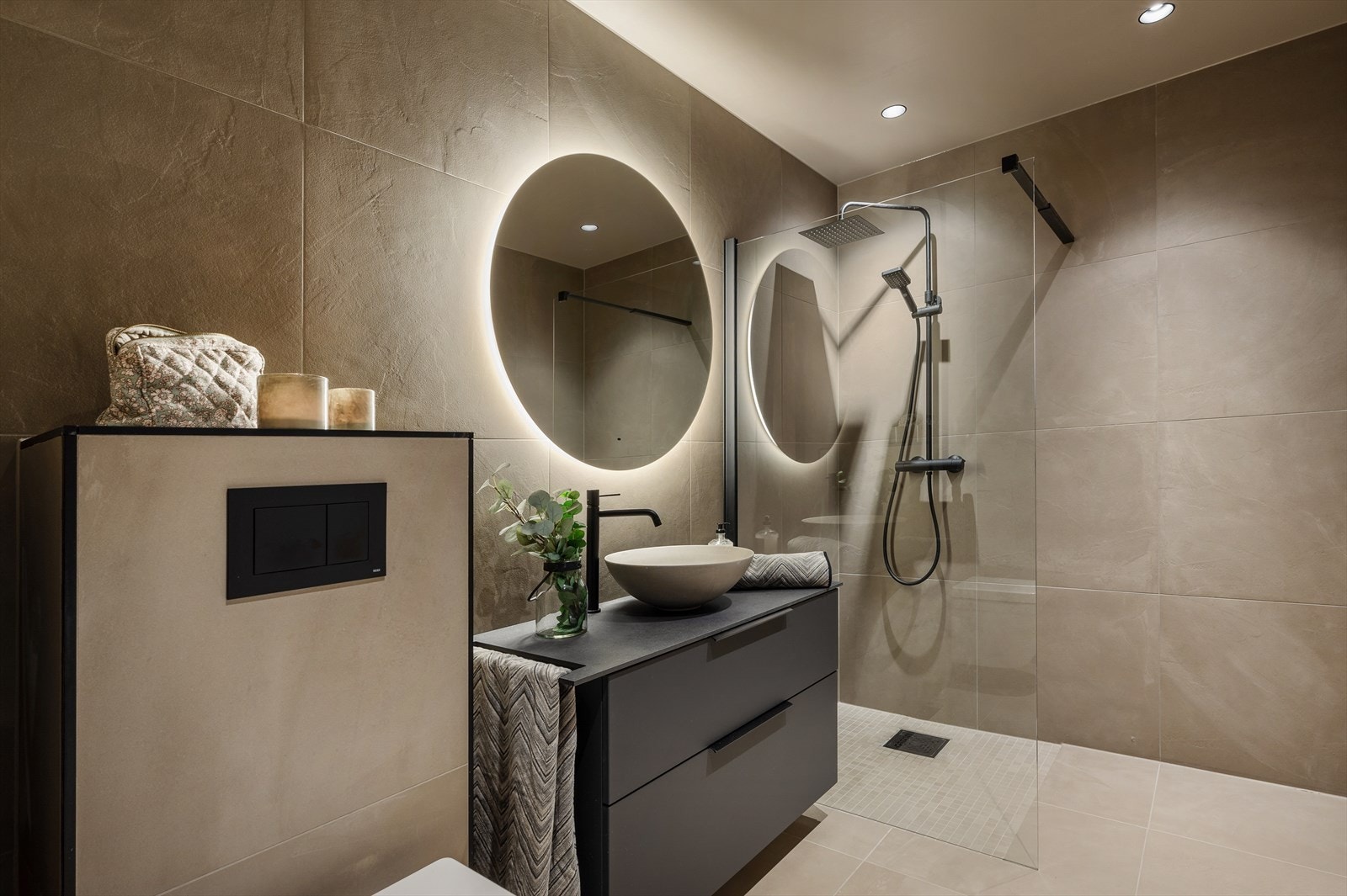 Badet har vegghengt toalett, servantinnredning og dusjhjørne Galleribilde