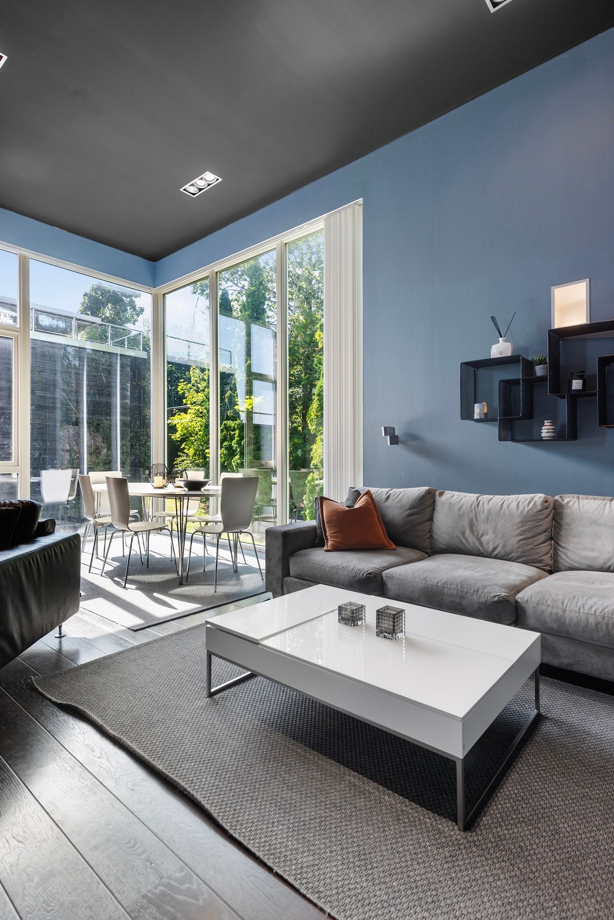 Store vindusflater kombinert med imponerende takhøyde gir stuen en luftig atmosfære og rikelig med naturlig lys Galleribilde