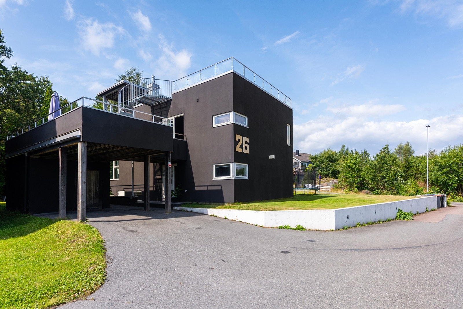 Boligen har parkering i asfaltert innkjørsel og i carport - Herfra kan du gå under tak til inngangspartiet Galleribilde