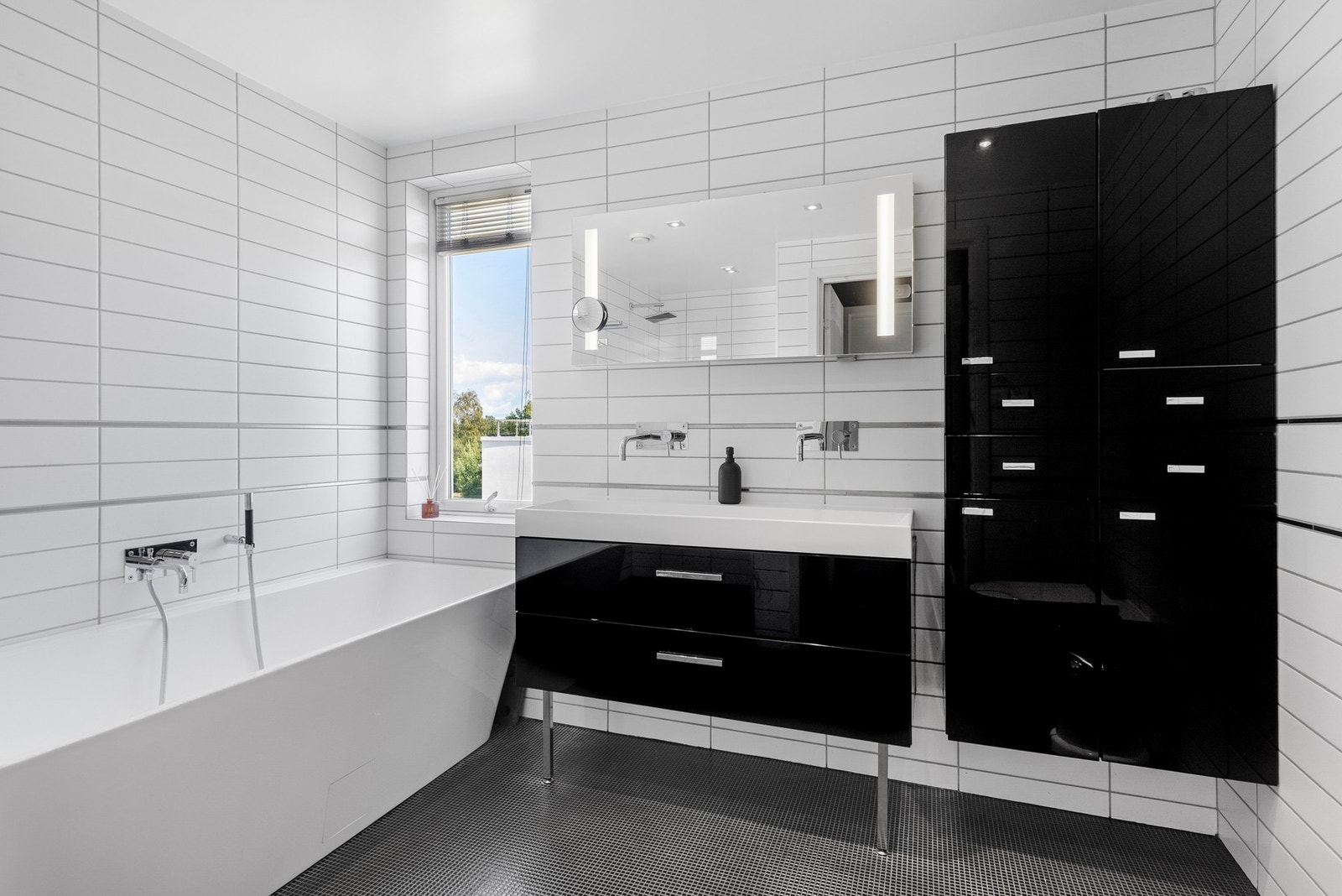 Her finner du også ett av boligens bad, utstyrt med et deilig badekar - et fredelig sted å slappe av etter en lang dag Galleribilde