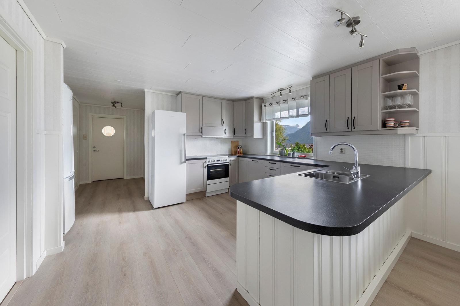 Kjøkkeninnredningen har malte fronter og benkeplate i laminat Galleribilde