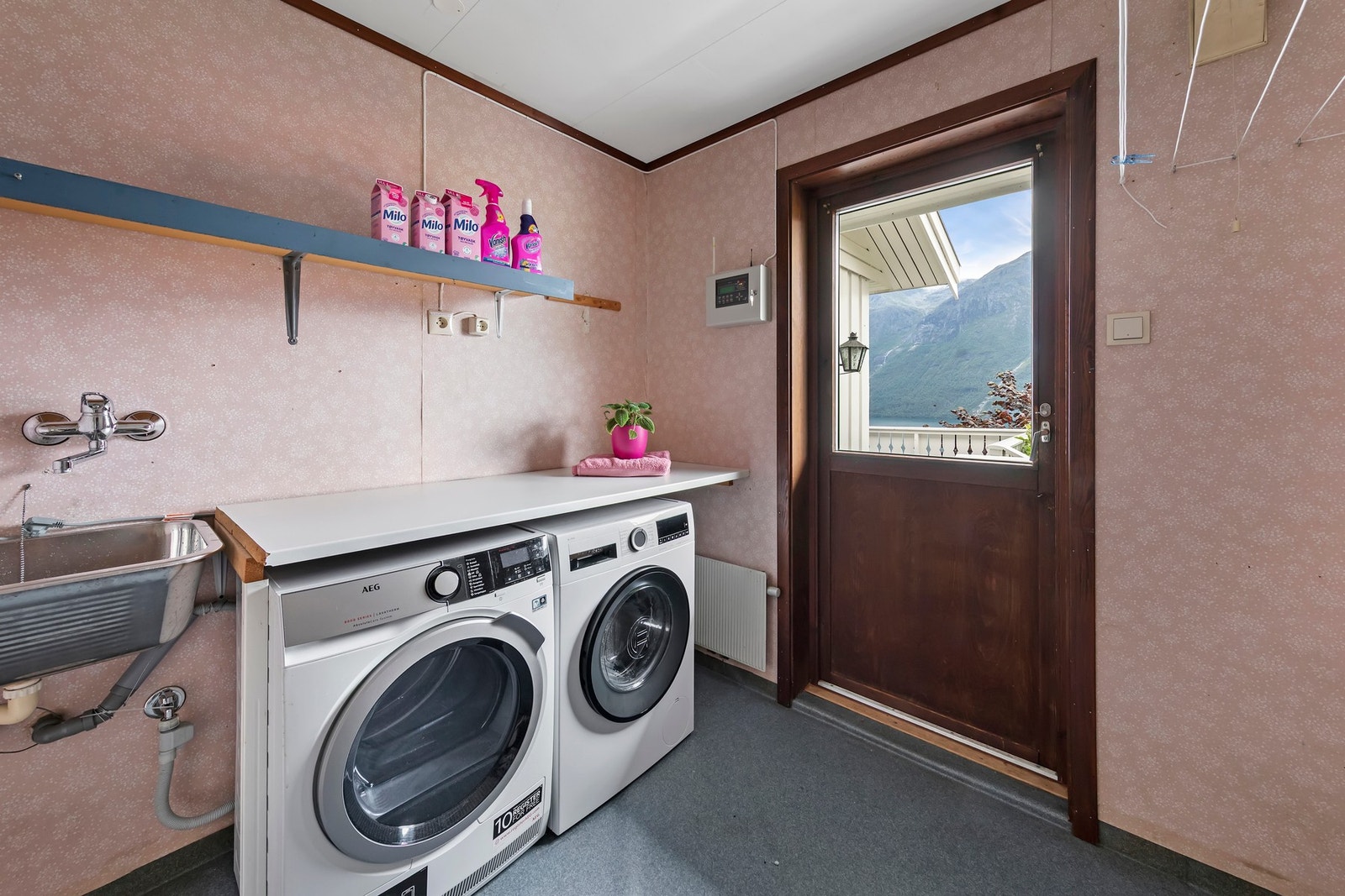 Vaskerommet har vinylbelegg på gulv og tapet på vegger. Vaskekum i stål og opplegg for vaskemaskin Galleribilde