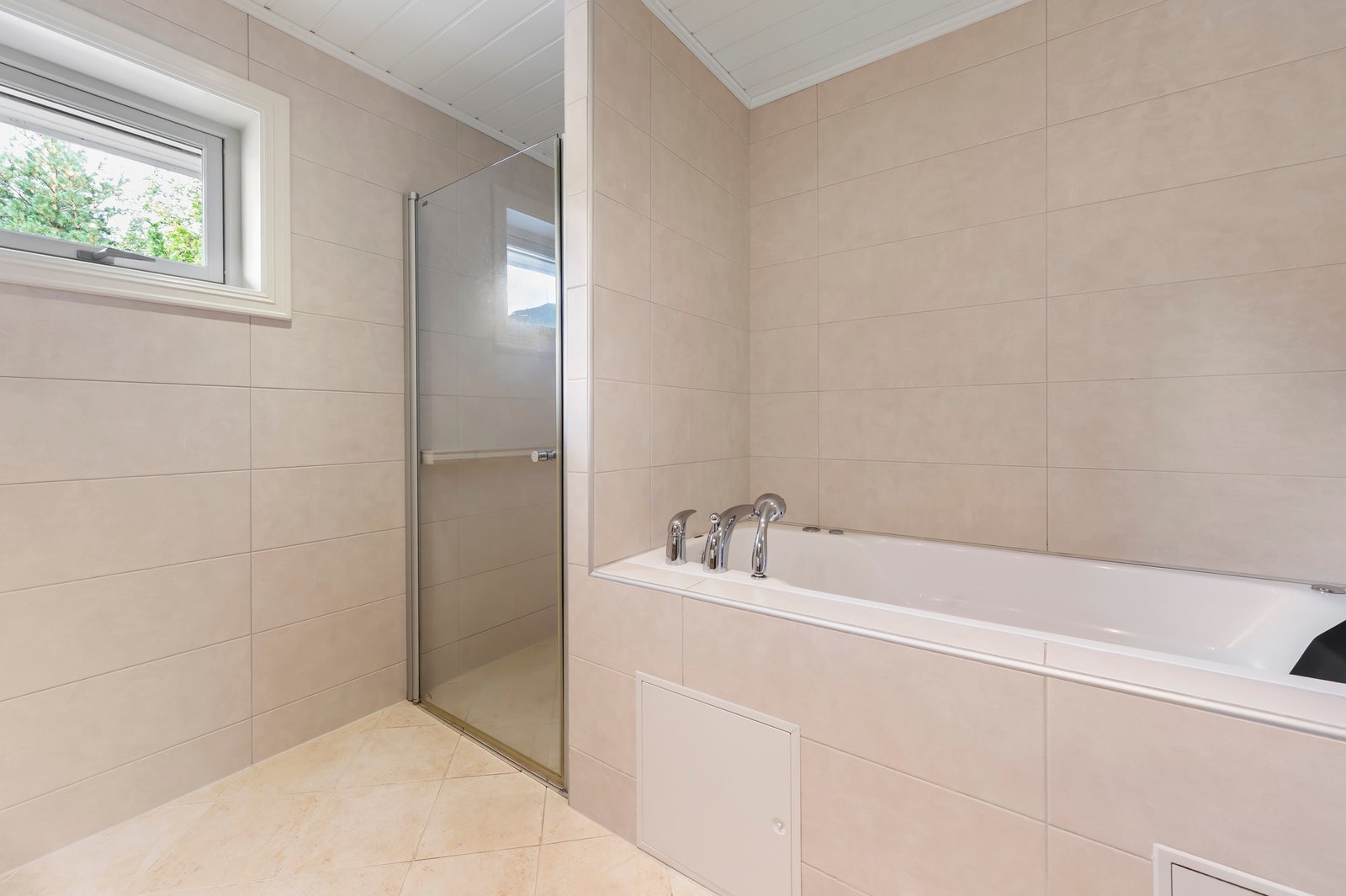 Innmurt badekar og flislagt dusjnisje Galleribilde