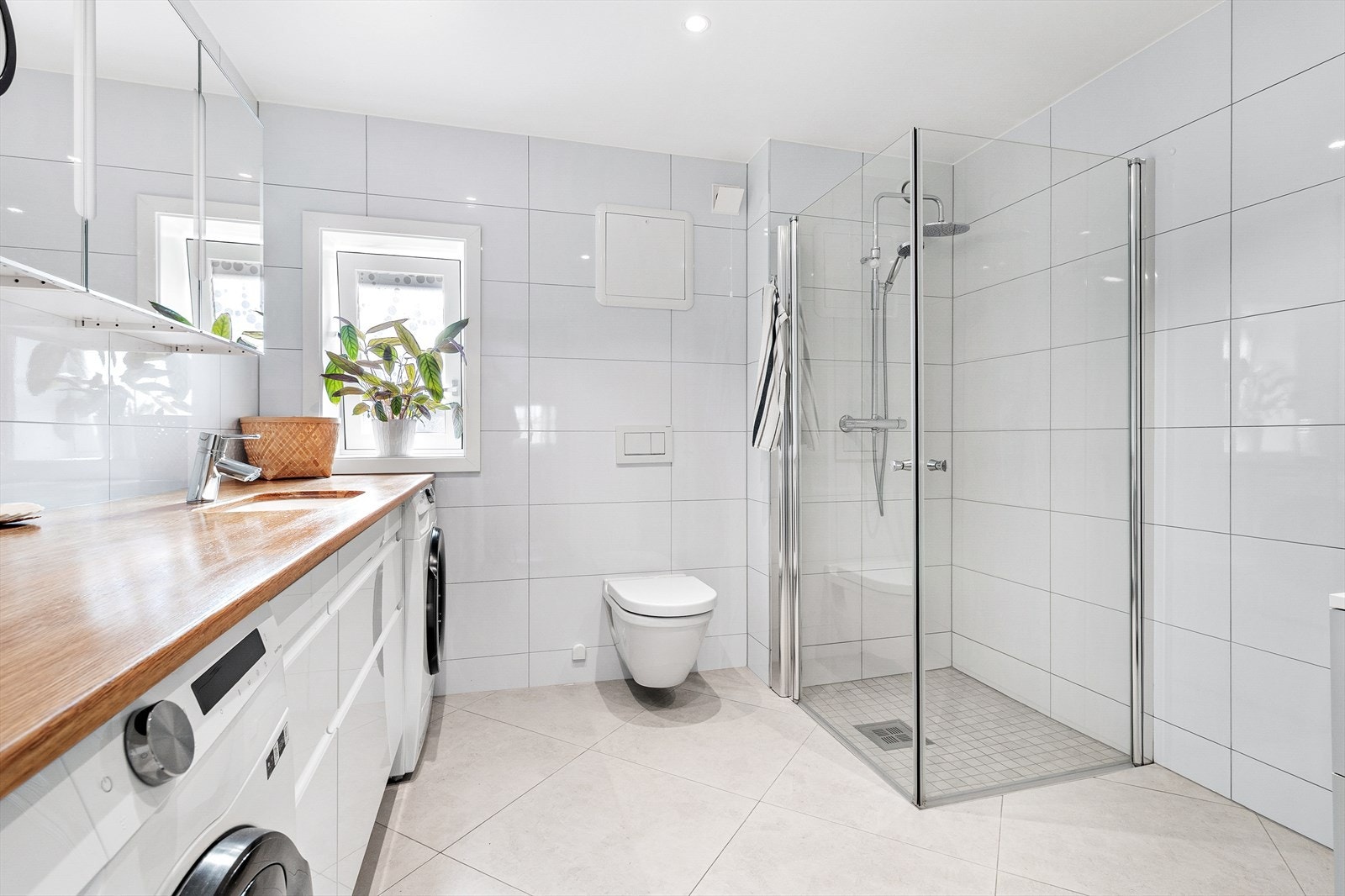 Stilrent bad fra 2022 med dusjhjørne og veggmontert toalett. Galleribilde