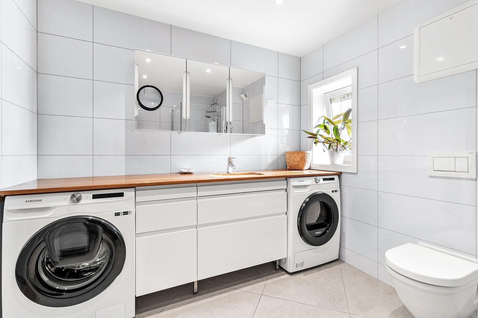 Moderne bad med servant, speil og opplegg for vaskemaskin. Galleribilde