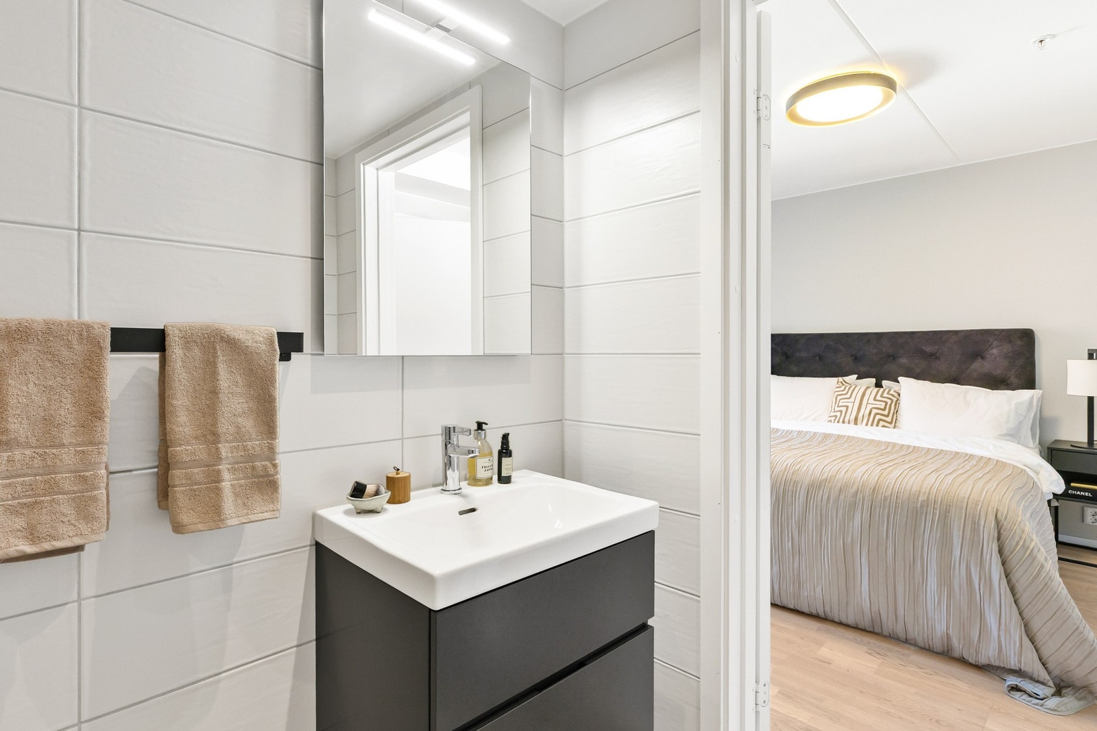 Lyst og stilrent bad med dusjhjørne med regndusj, vegghengt toalett og moderne servant, direkte tilknyttet mastersoverommet. Galleribilde