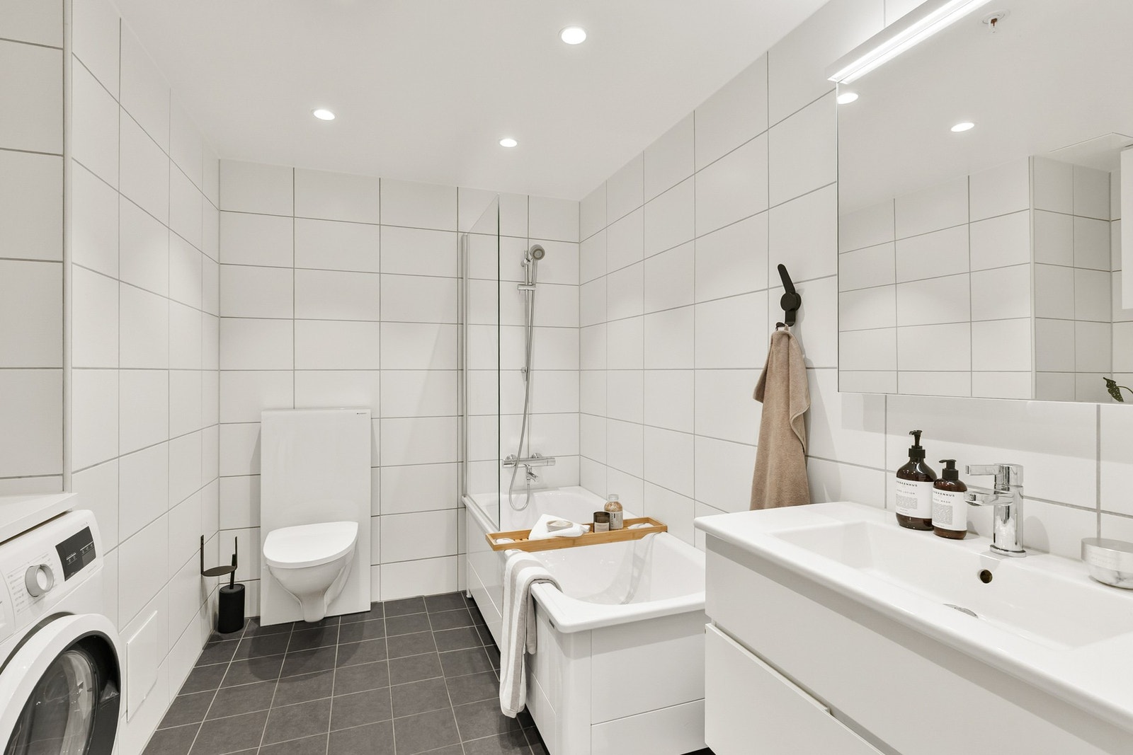 Boligens andre bad er utstyrt med vask, vegghengt toalett, badekar, opplegg for vaskemaskin og tørketrommel, samt oppbevaringsmuligheter. Galleribilde