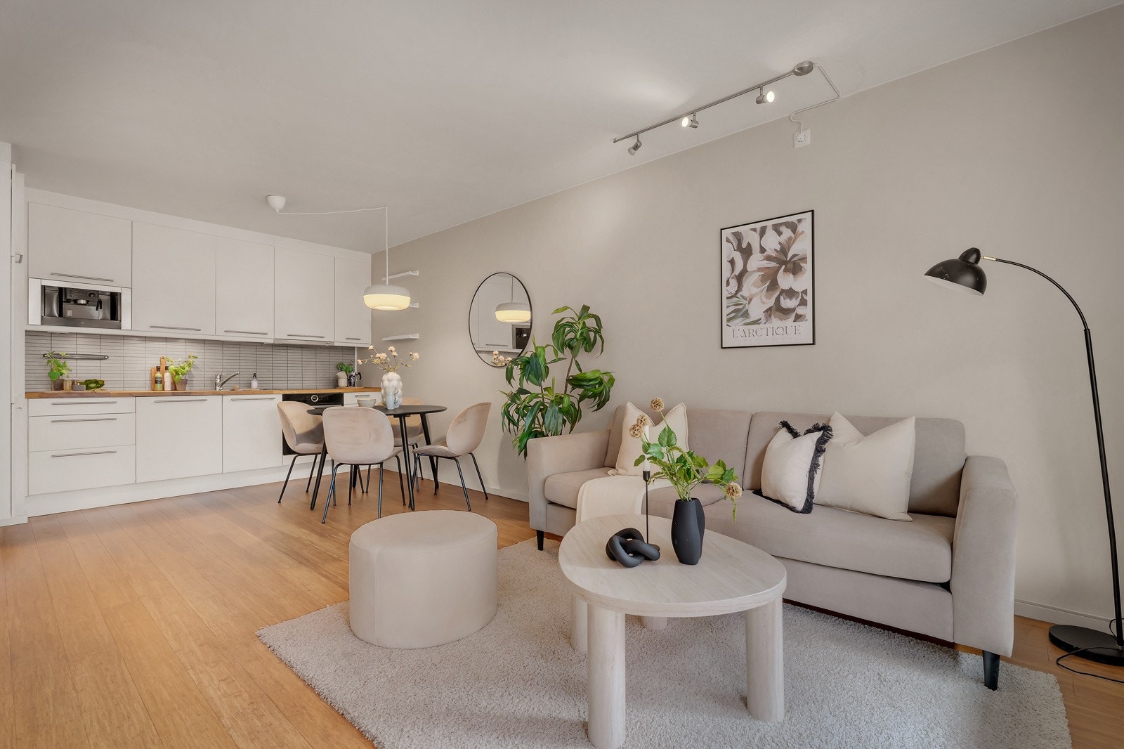 - Romslig stue/kjøkken med slette vegger malt i en nydelig beigetone og lys parkett - Galleribilde