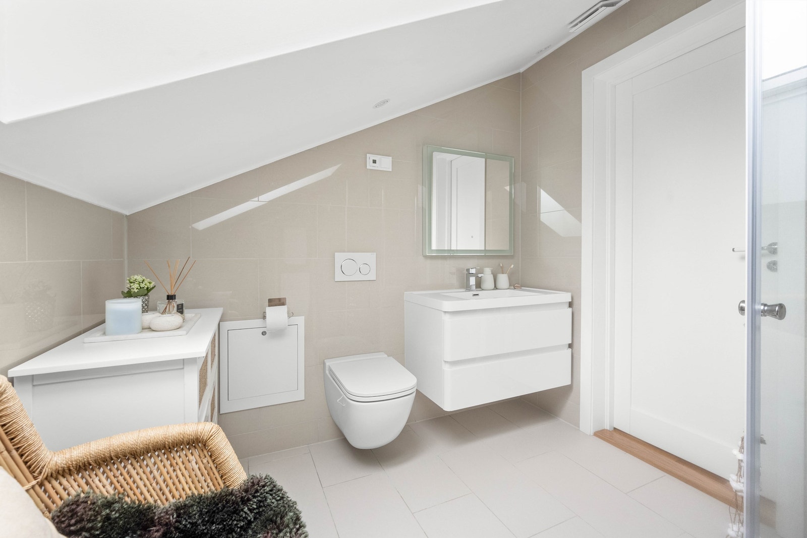 Det er fliser på vegg og malt himling. Veggmontert toalett. Galleribilde