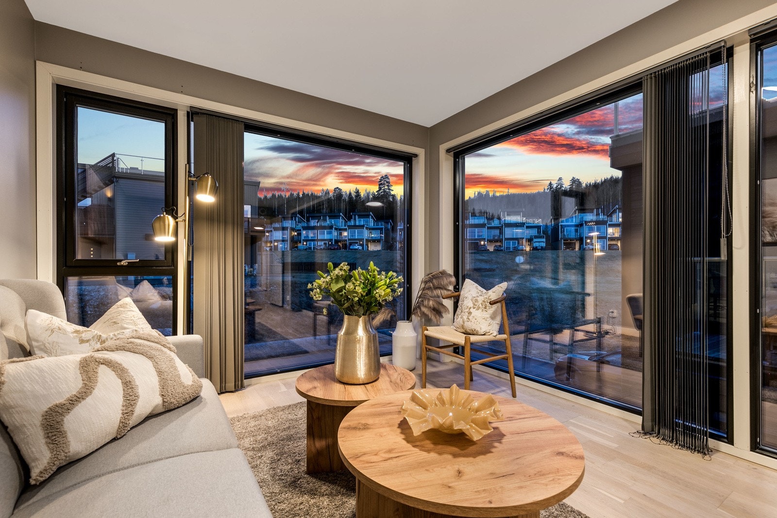 Lys, luftig og åpen Tv-stue med store vindusflater fra gulv til tak. Det er montert stilrene lameller foran vinduene som skjermer godt for solen på de varmeste dagene. Galleribilde