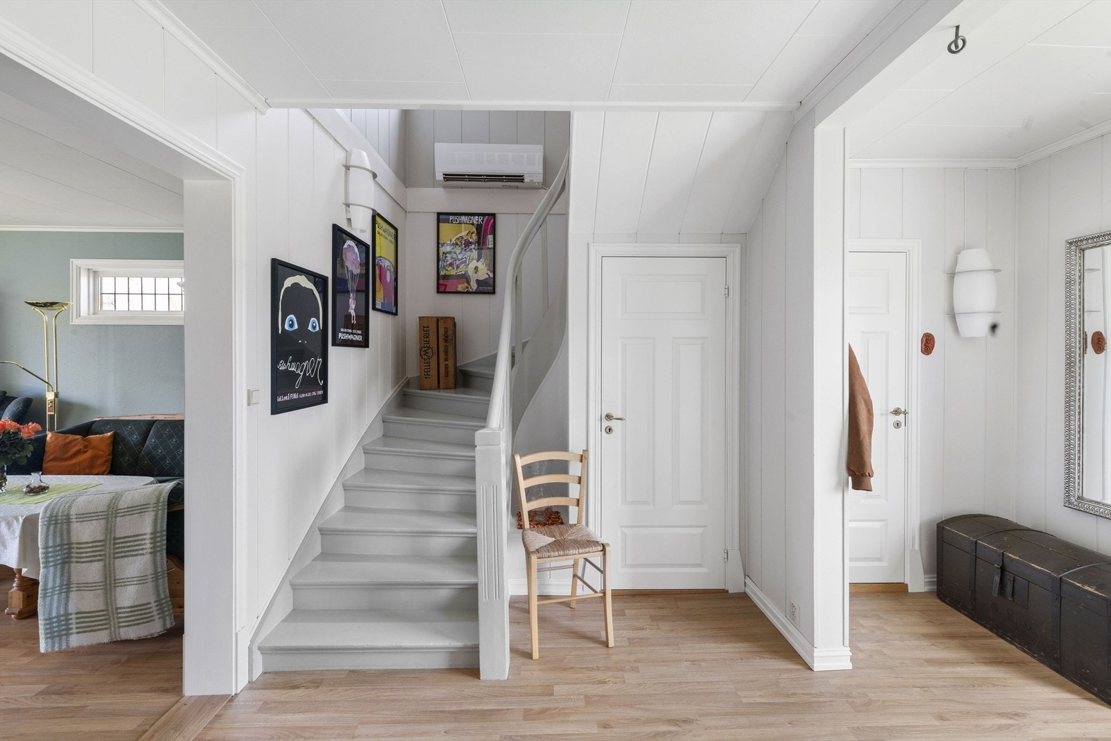 Lyst og romslig inngangsparti med trapp til andre etasje. Veggene er hvitmalte, og gulvet er i lys parkett. Galleribilde