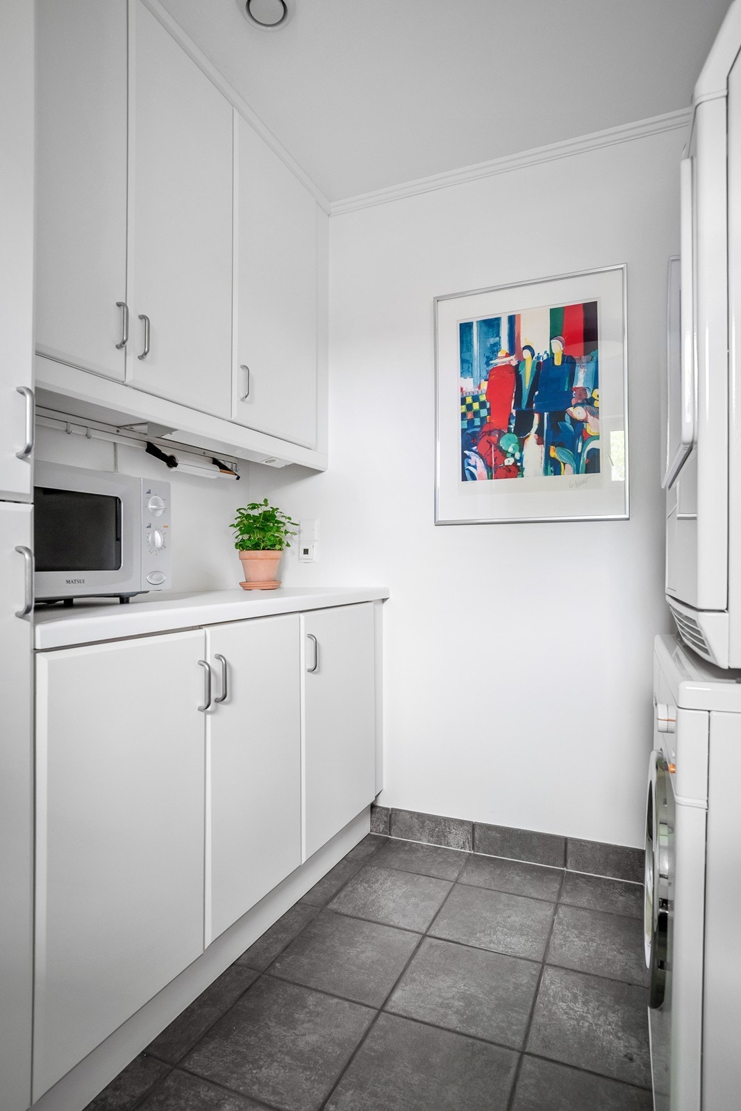 Praktisk innredet vaskerom med høyskap, benkeplass og god oppbevaring. Galleribilde