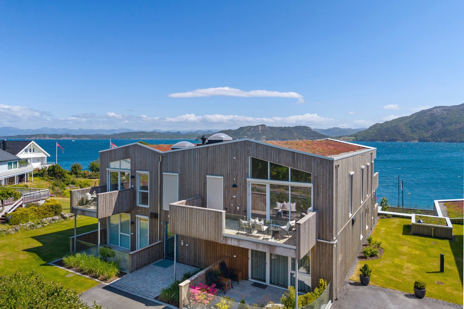 Bebyggelsen trapper ned mot sjøen, og fellesområdet er pent opparbeidet med grøntarealer, benker, gangstier og lekeapparater til glede for de minste. Galleribilde