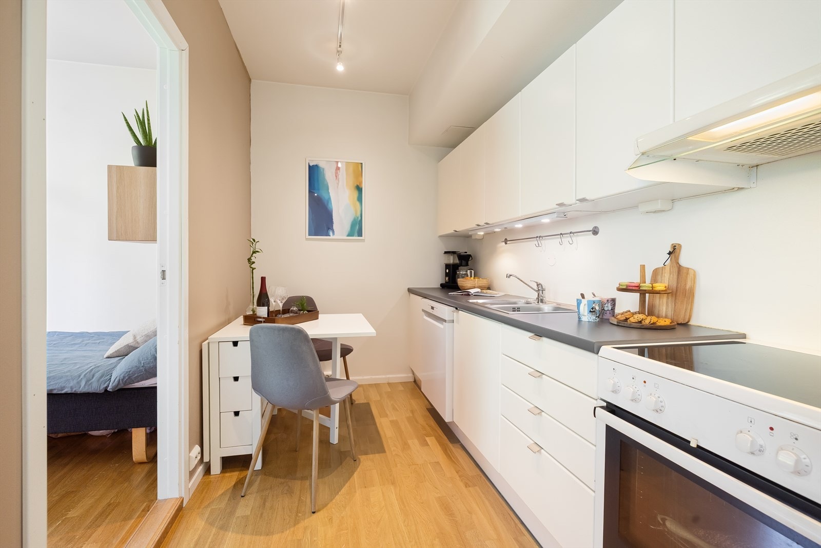 Kjøkkenet har frittstående hvitevarer med avsatt plass til oppvaskmaskin, kjøl/fryseskap og komfyr med platetopp med mekanisk avtrekksvifte over stekesonen. Galleribilde