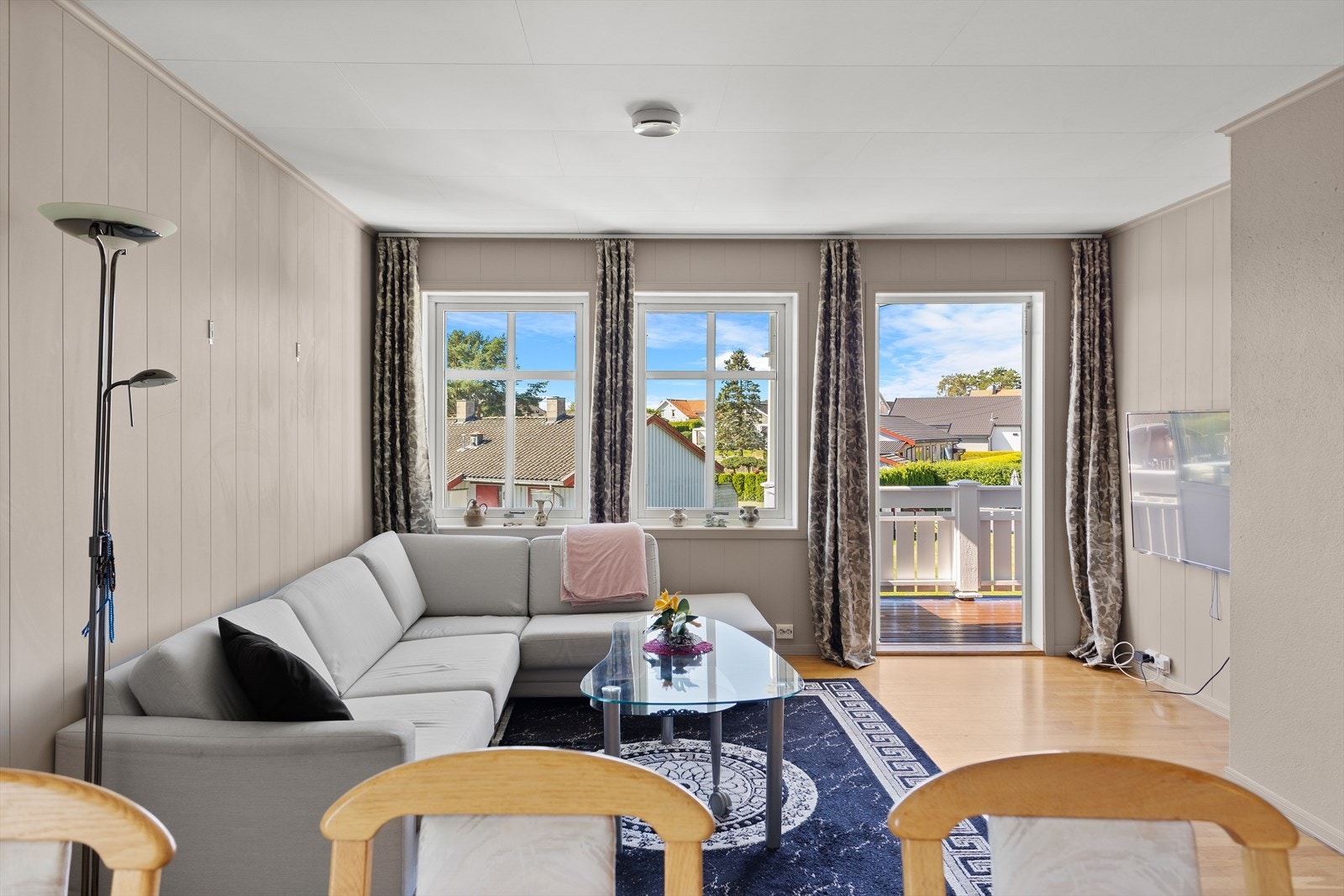 Store vindusflater i stuen slipper inn rikelig med dagslys og forsterker den åpne og lyse romfølelsen Galleribilde